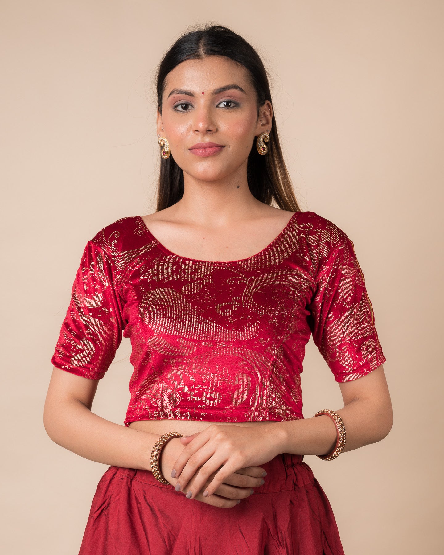 Model wearing a maroon velvet stretchable blouse with gold paisley prints, elbow sleeves, and round neckline.