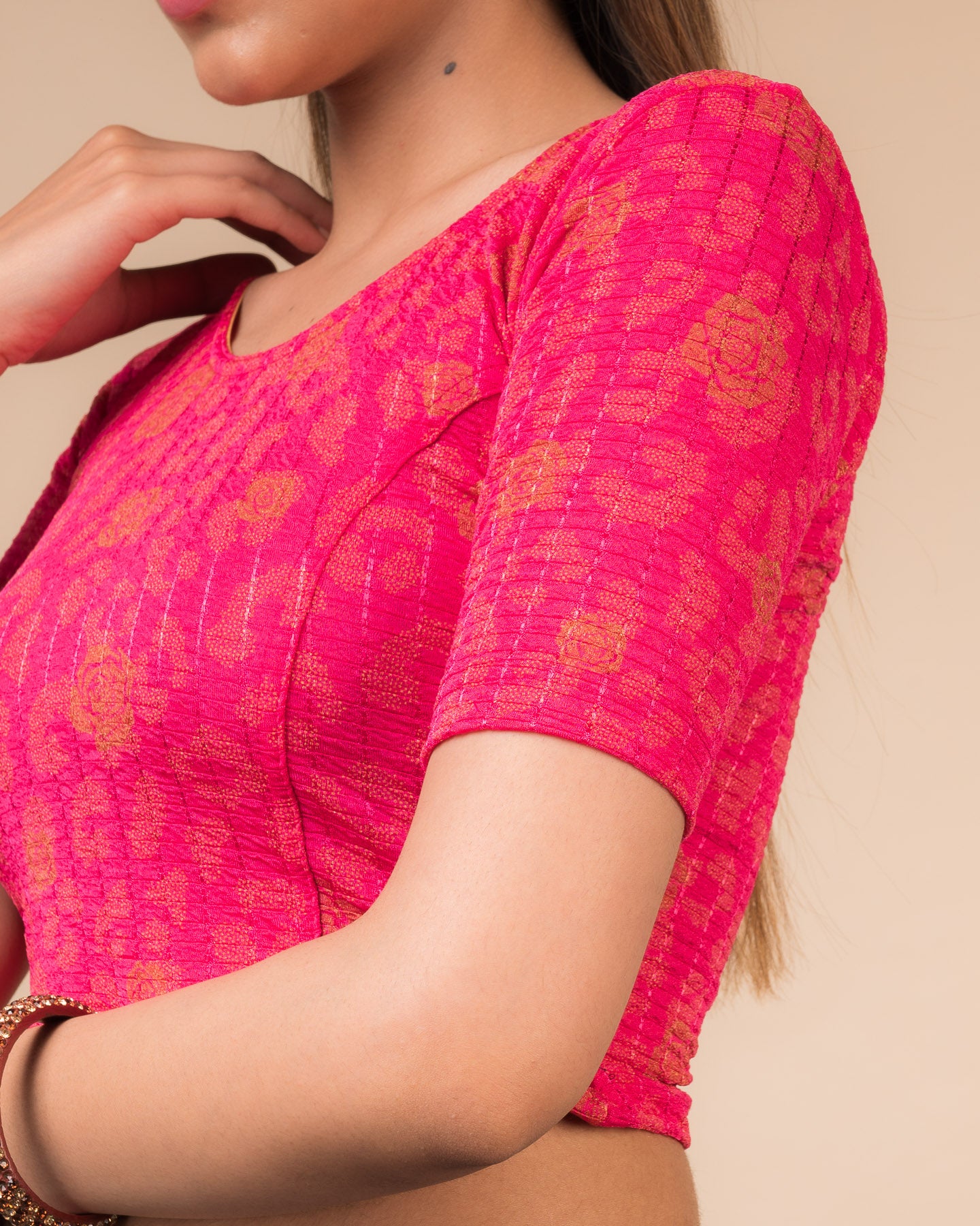 Close-up of the fabric’s metallic floral foil design and stretchable texture