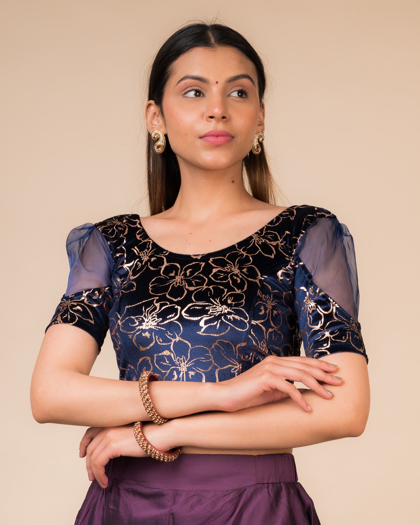 Model wearing a velvet stretchable blouse with floral-sequin embellishments, puff elbow sleeves, and round neckline