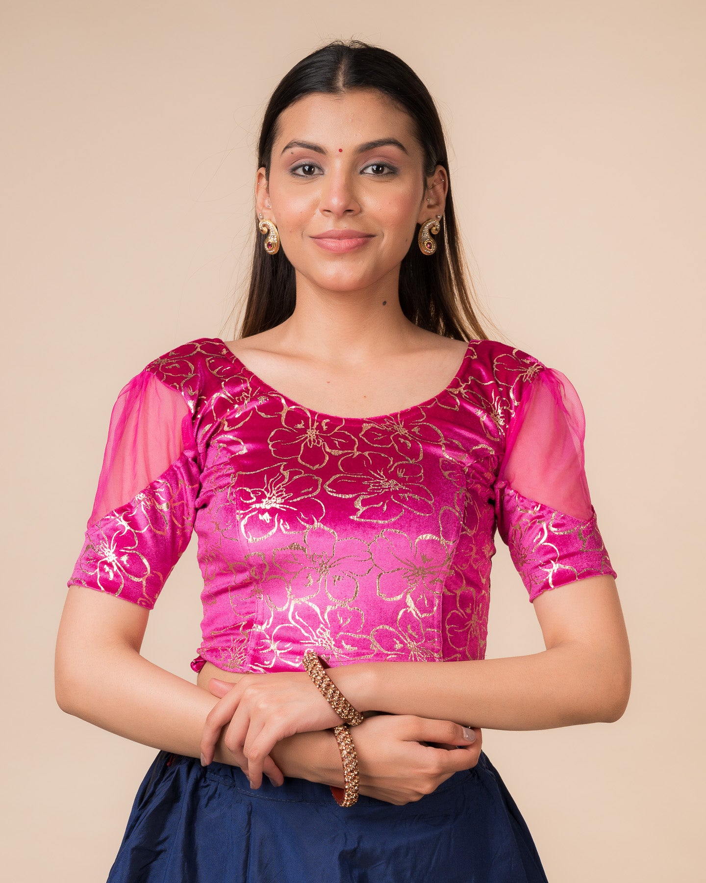 Model wearing a velvet stretchable blouse with floral-sequin embellishments, puff elbow sleeves, and round neckline