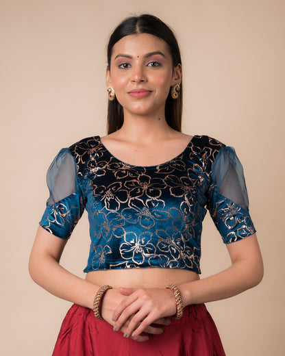 Model wearing a velvet stretchable blouse with floral-sequin embellishments, puff elbow sleeves, and round neckline