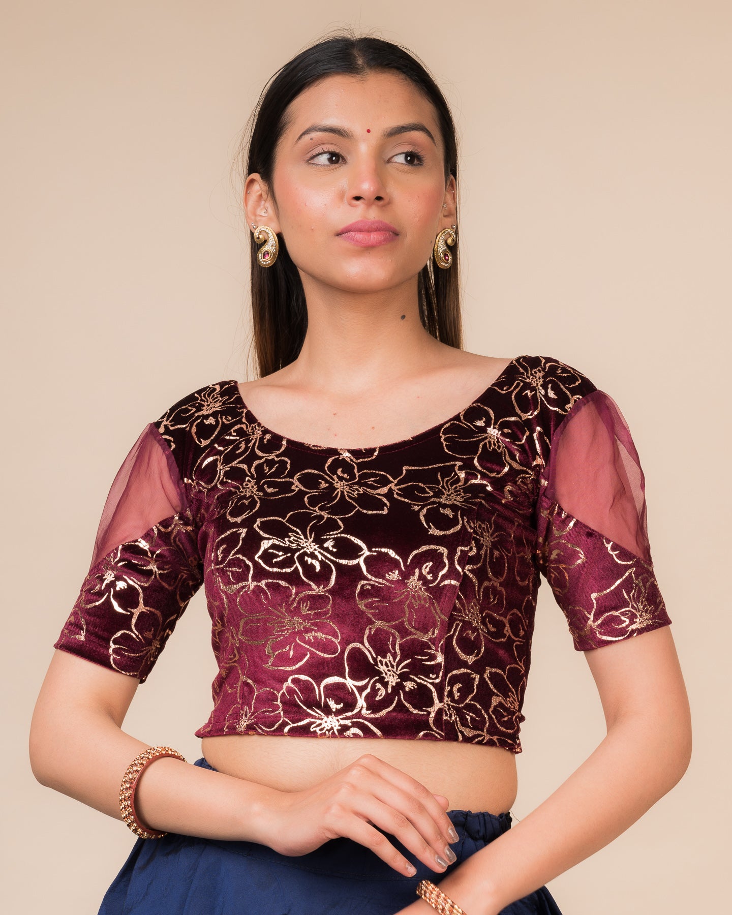 Model wearing a velvet stretchable blouse with floral-sequin embellishments, puff elbow sleeves, and round neckline