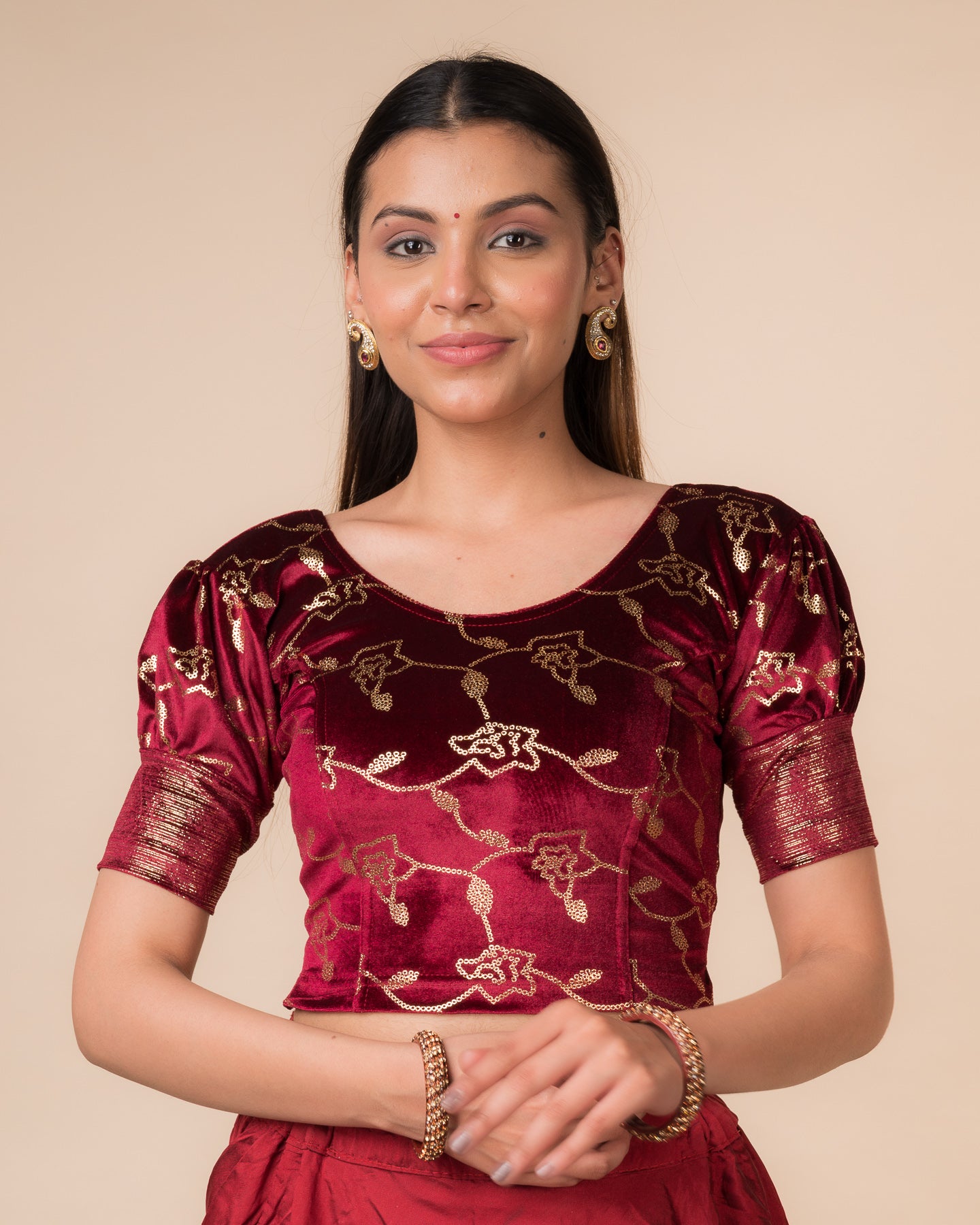 Model wearing a velvet blouse with metallic sequin foil, elbow puff sleeves, and round neckline