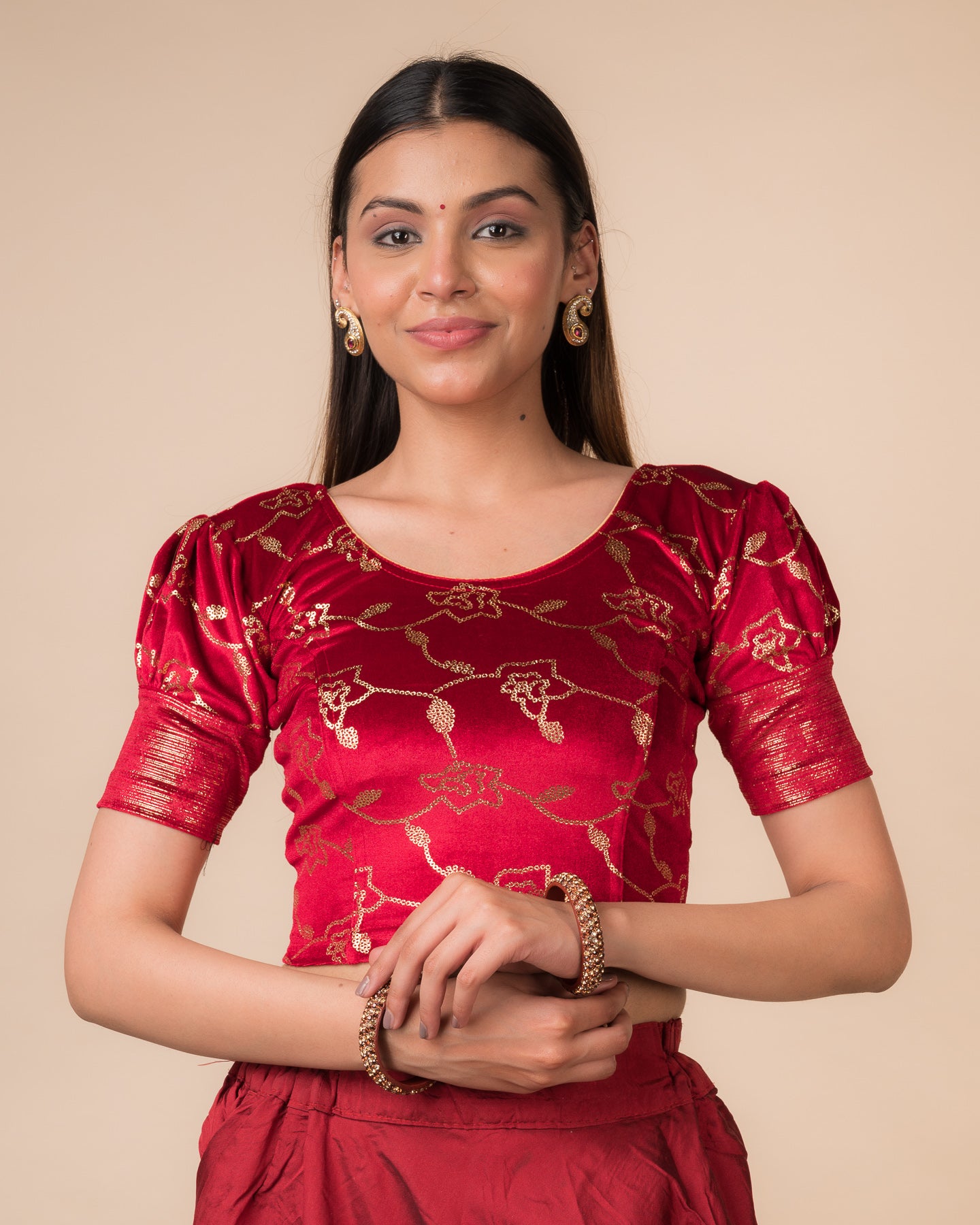 Model wearing a velvet blouse with metallic sequin foil, elbow puff sleeves, and round neckline