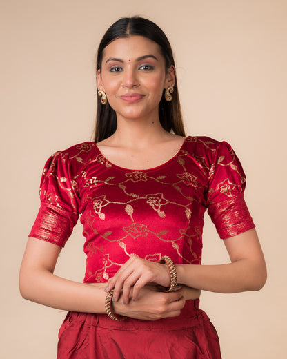 Model wearing a velvet blouse with metallic sequin foil, elbow puff sleeves, and round neckline