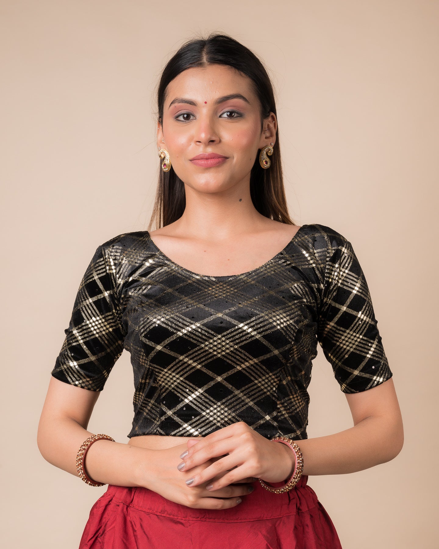 Model wearing a stretchable blouse featuring embossed Burberry‑check pattern with sequin shine, round neckline, and elbow sleeves