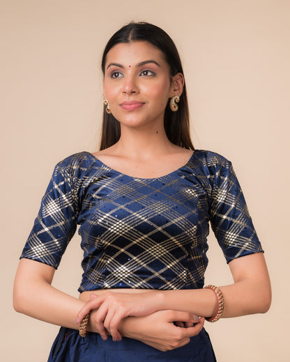 Model wearing a stretchable blouse featuring embossed Burberry‑check pattern with sequin shine, round neckline, and elbow sleeves