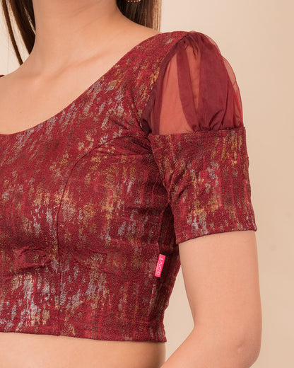 Close-up of the multi-foil textured knit and sheer sleeve detail