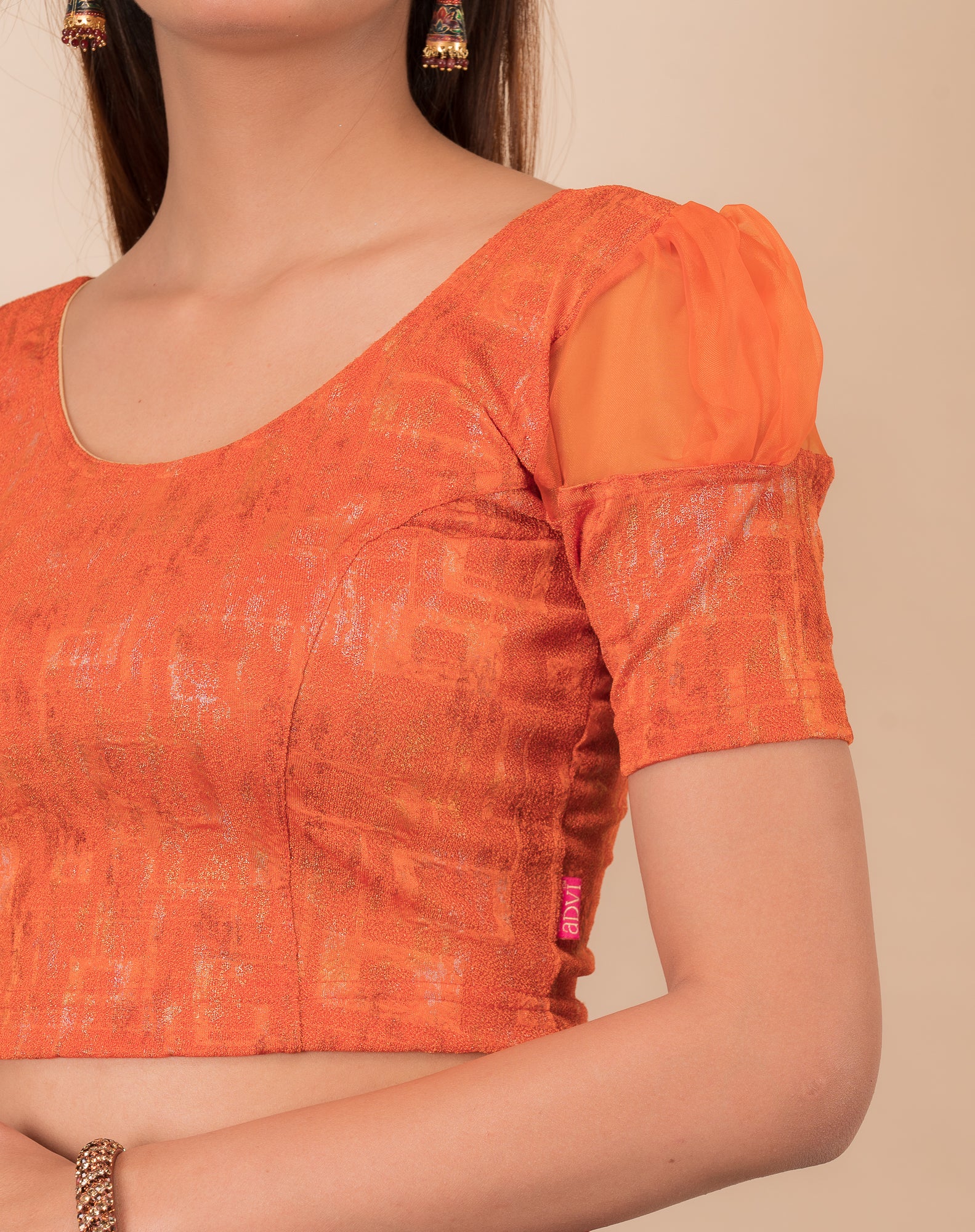 Close-up of the multi-foil textured knit and sheer sleeve detail
