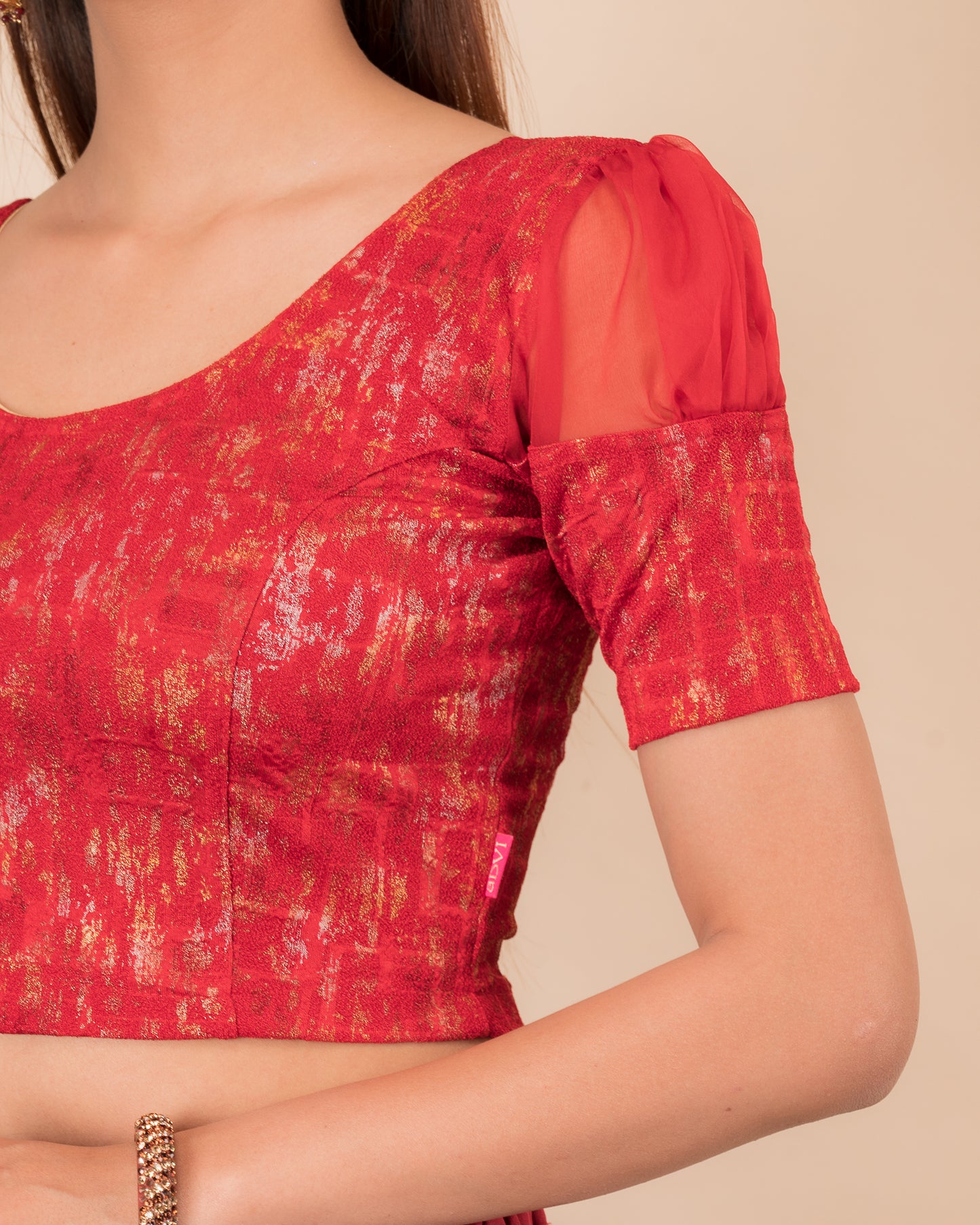 Close-up of the multi-foil textured knit and sheer sleeve detail