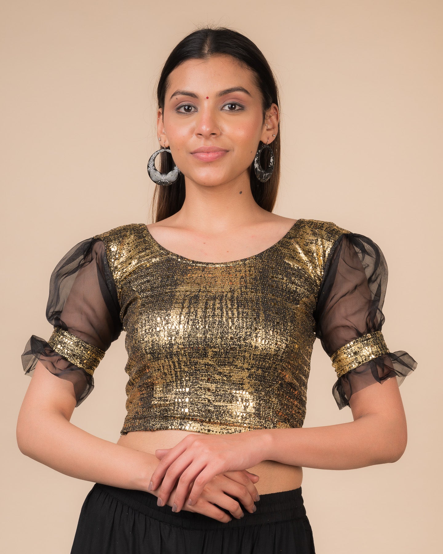  Model wearing a black metallic stretchable blouse with puff sleeves and a round neckline.