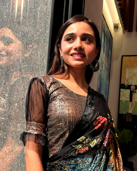 Model pairing the black metallic puff sleeve blouse with a traditional saree for a festive occasion.