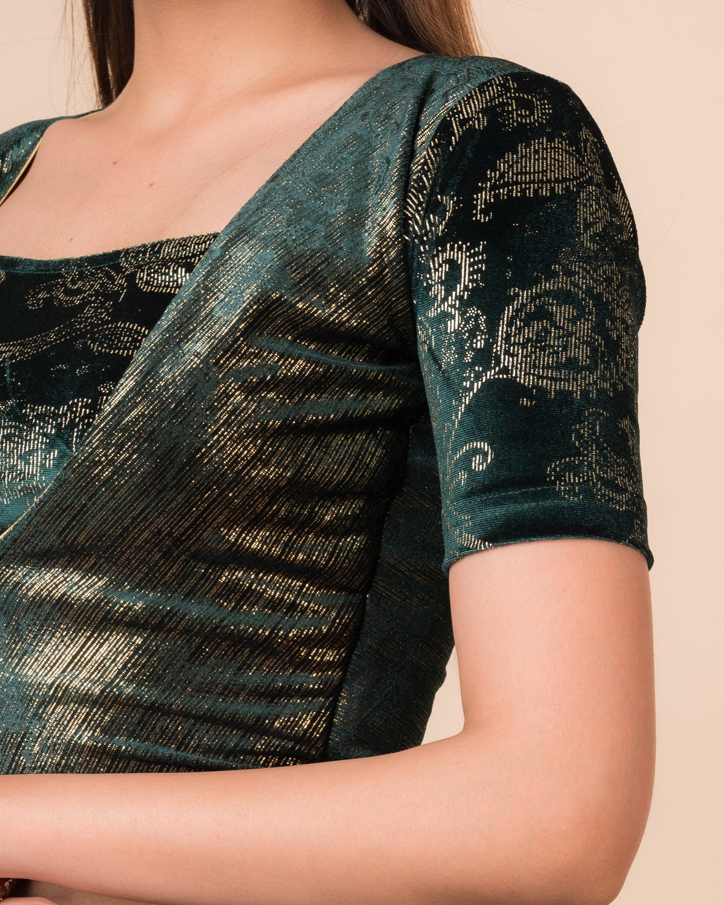 Close-up of the bottle green-colored velvet fabric detailing the texture and embellishments of the readymade blouse.