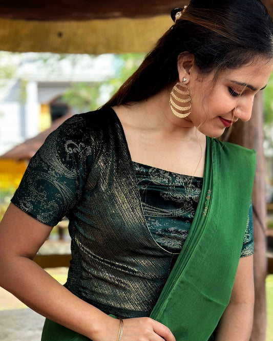 Model pairing the bottle green-colored velvet embellished stretchable choli-style blouse with a traditional saree, demonstrating a complete festive look.