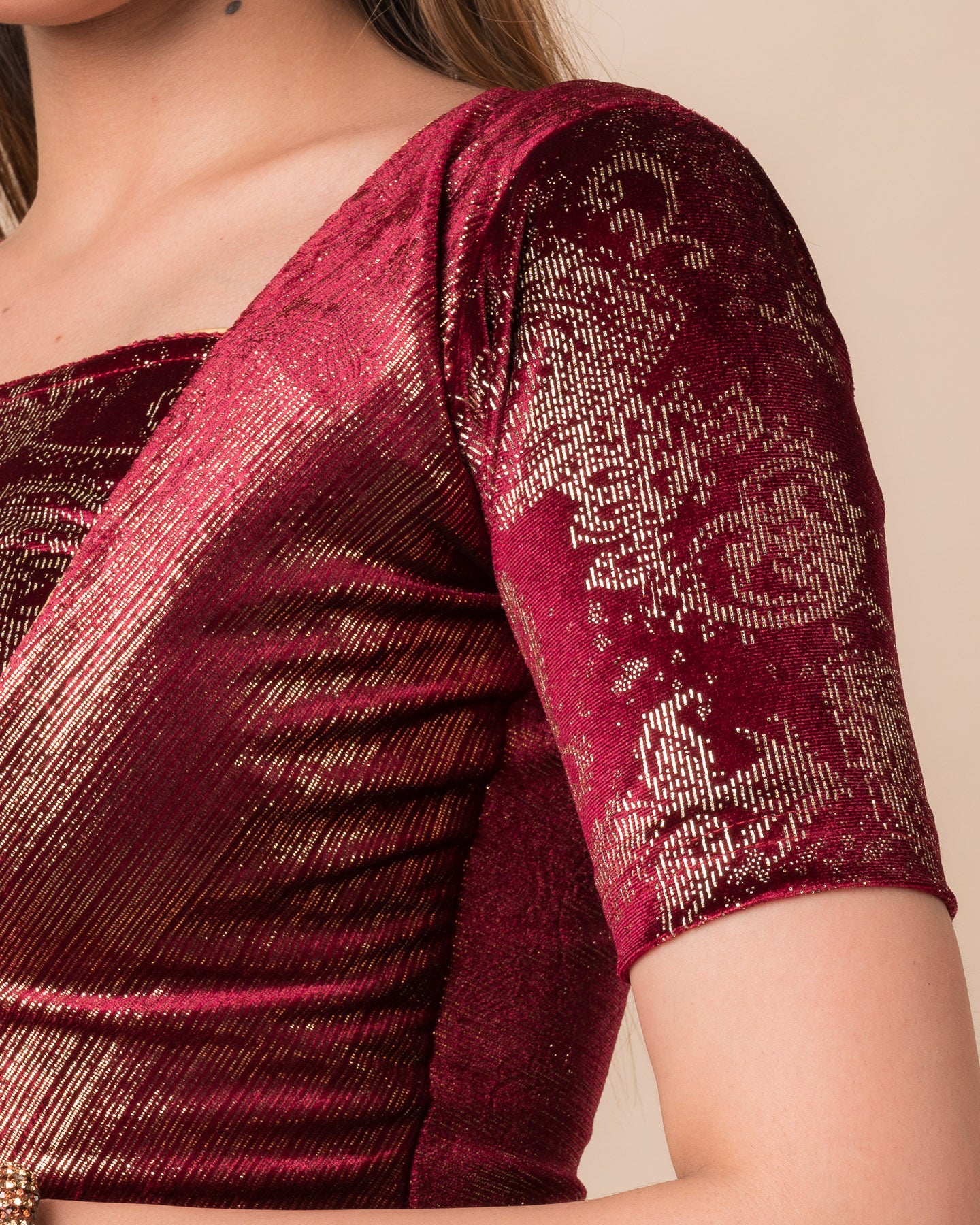 Close-up of the maroon-colored velvet fabric detailing the texture and embellishments of the readymade blouse.