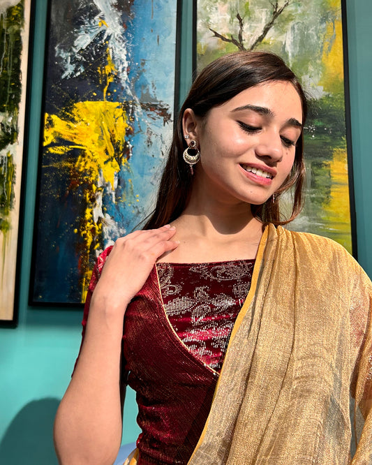 Model pairing the maroon-colored velvet embellished stretchable choli-style blouse with a traditional saree, demonstrating a complete festive look.
