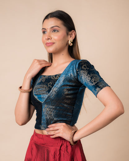 Side profile of the teal blue-colored velvet embellished stretchable choli-style blouse highlighting the fit and sleeve length.