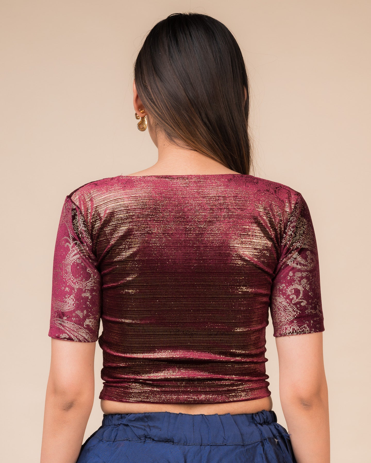 Rear view of the wine-colored velvet embellished stretchable choli-style blouse showcasing the deep round back design.