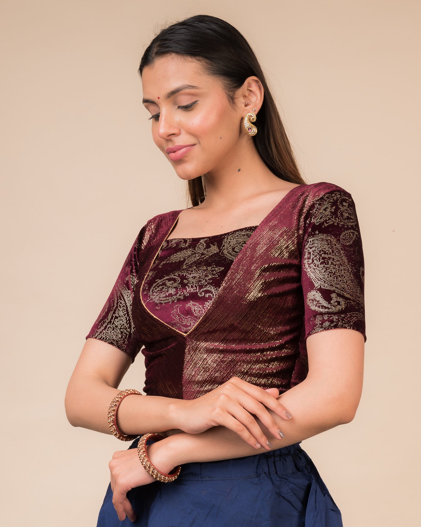 Side profile of the wine-colored velvet embellished stretchable choli-style blouse highlighting the fit and sleeve length.
