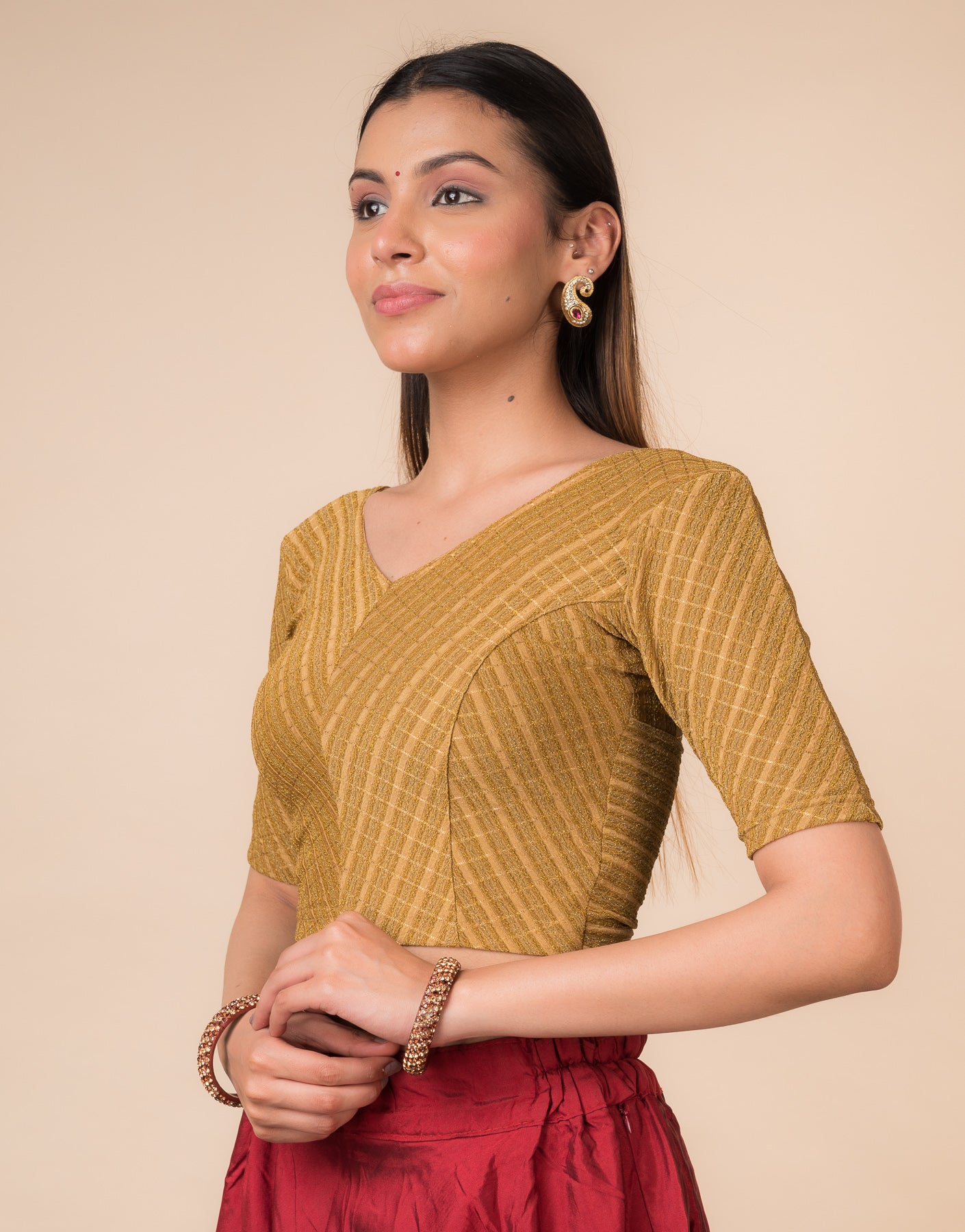Side profile of the dark gold zari stretchable blouse highlighting the fit and sleeve length.