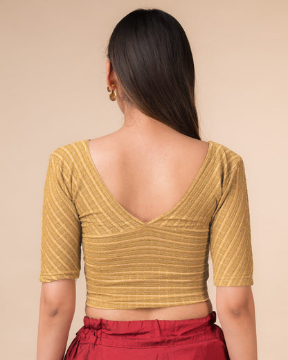 Rear view of the beige gold zari stretchable blouse showcasing the deep V-back design.
