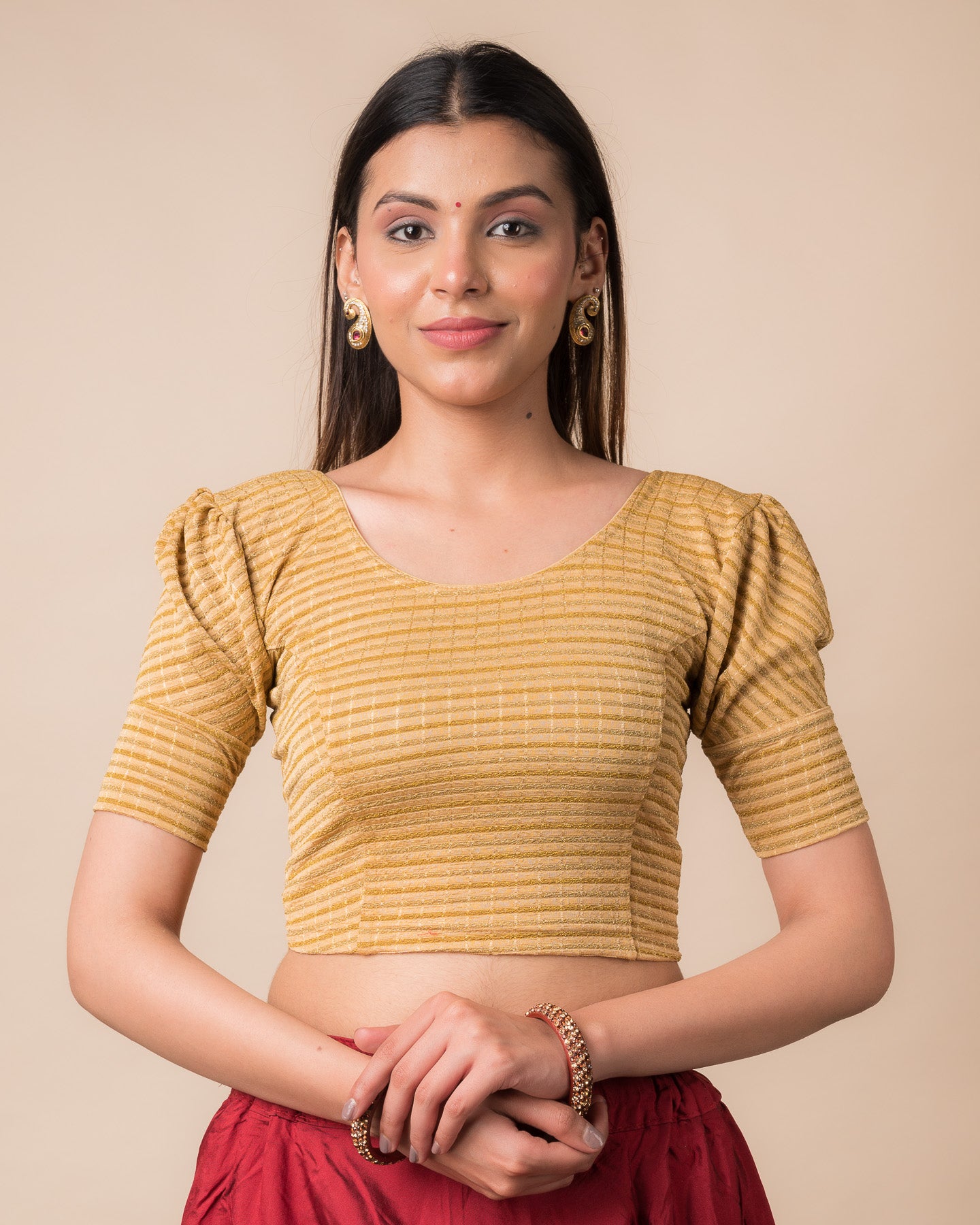 Model wearing a zari single-stripe stretchable readymade blouse with puff elbow sleeves and round neckline.