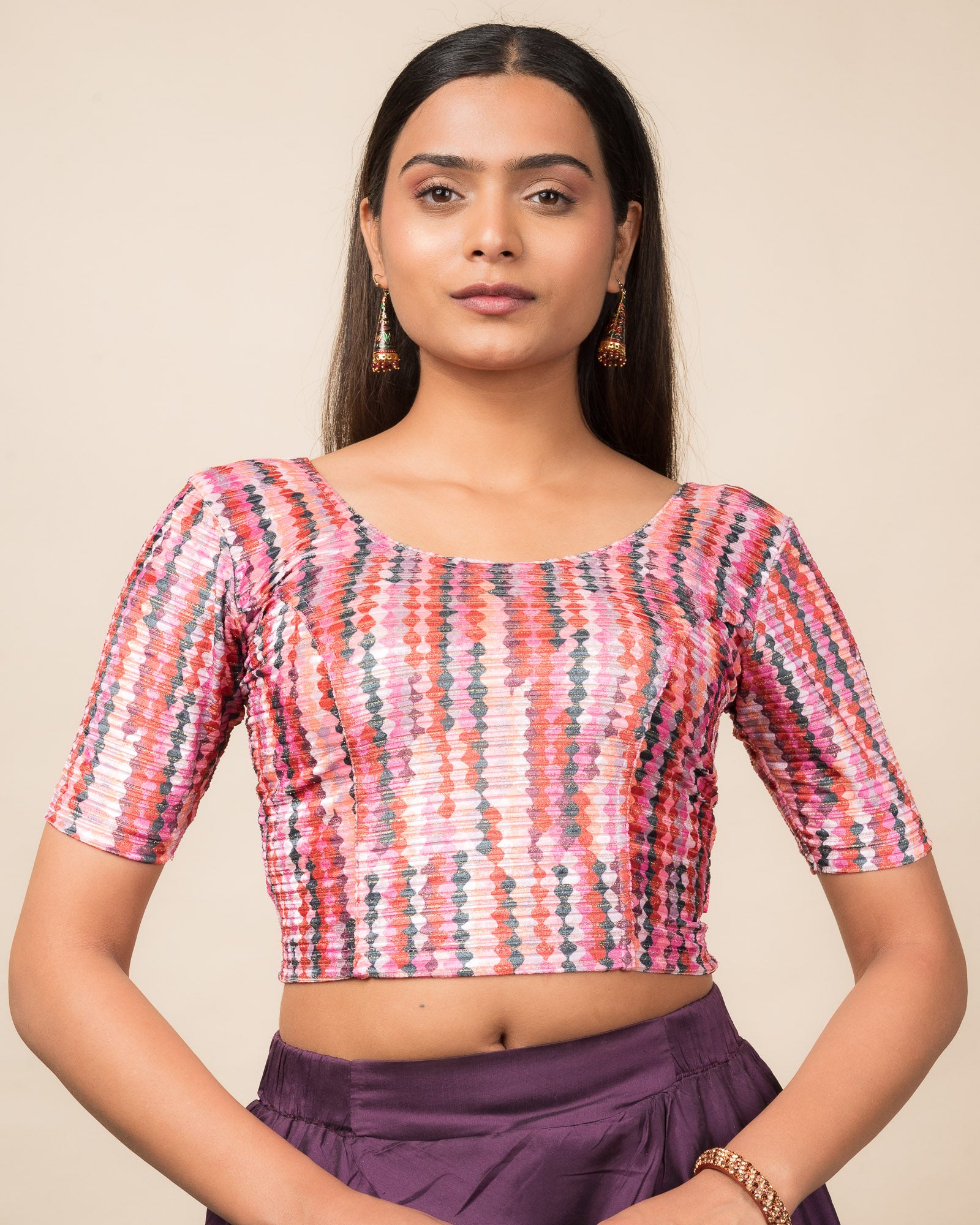 Model wearing a velvet stretchable readymade blouse with elbow sleeves and round neckline featuring modern abstract print.
