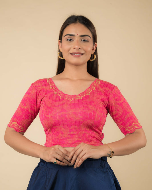 Model wearing a rani-colored stretchable readymade blouse with zari embroidery, elbow sleeves, and scalloped round neckline