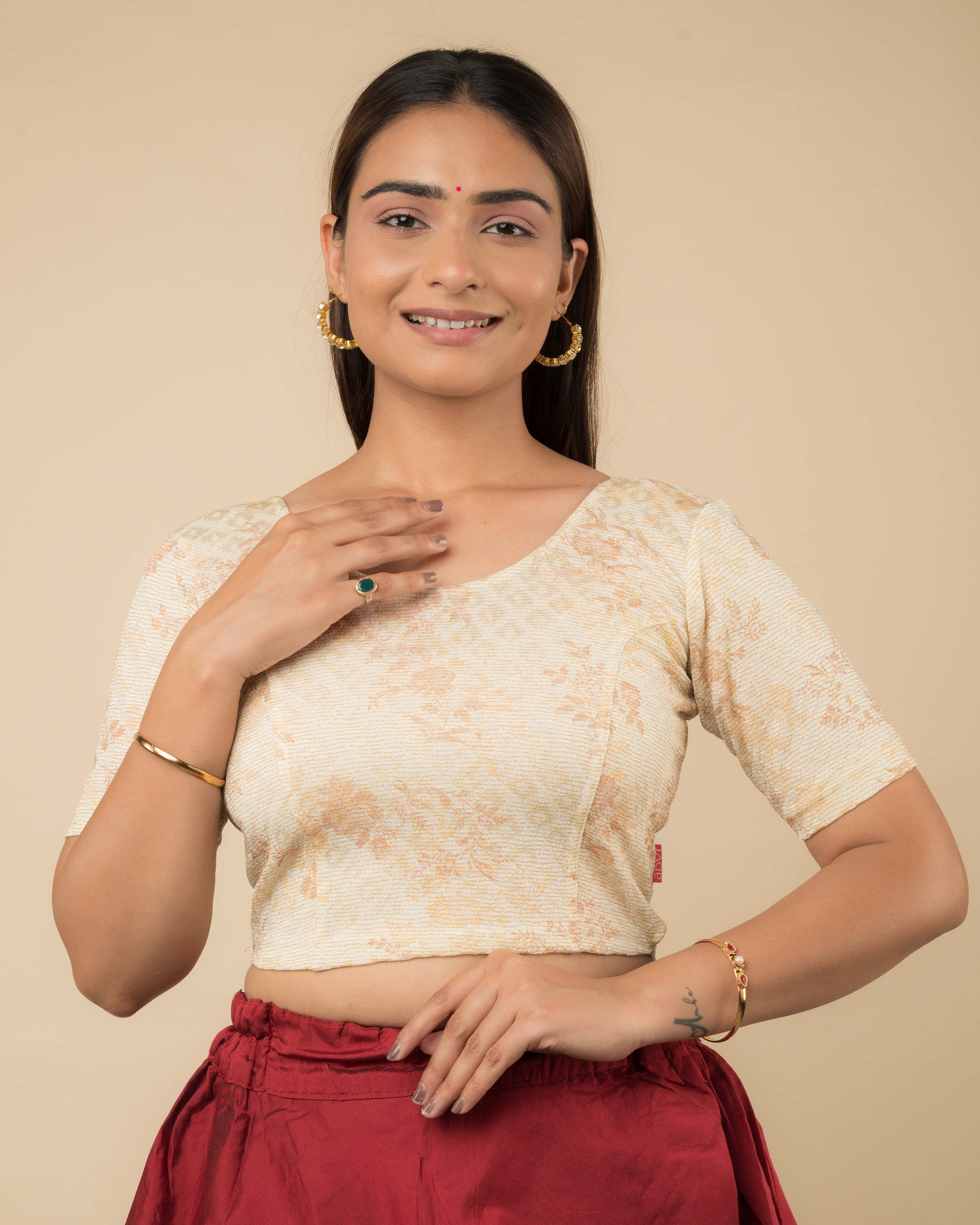  Model wearing a metallic floral stretchable readymade blouse with elbow sleeves and round neckline.