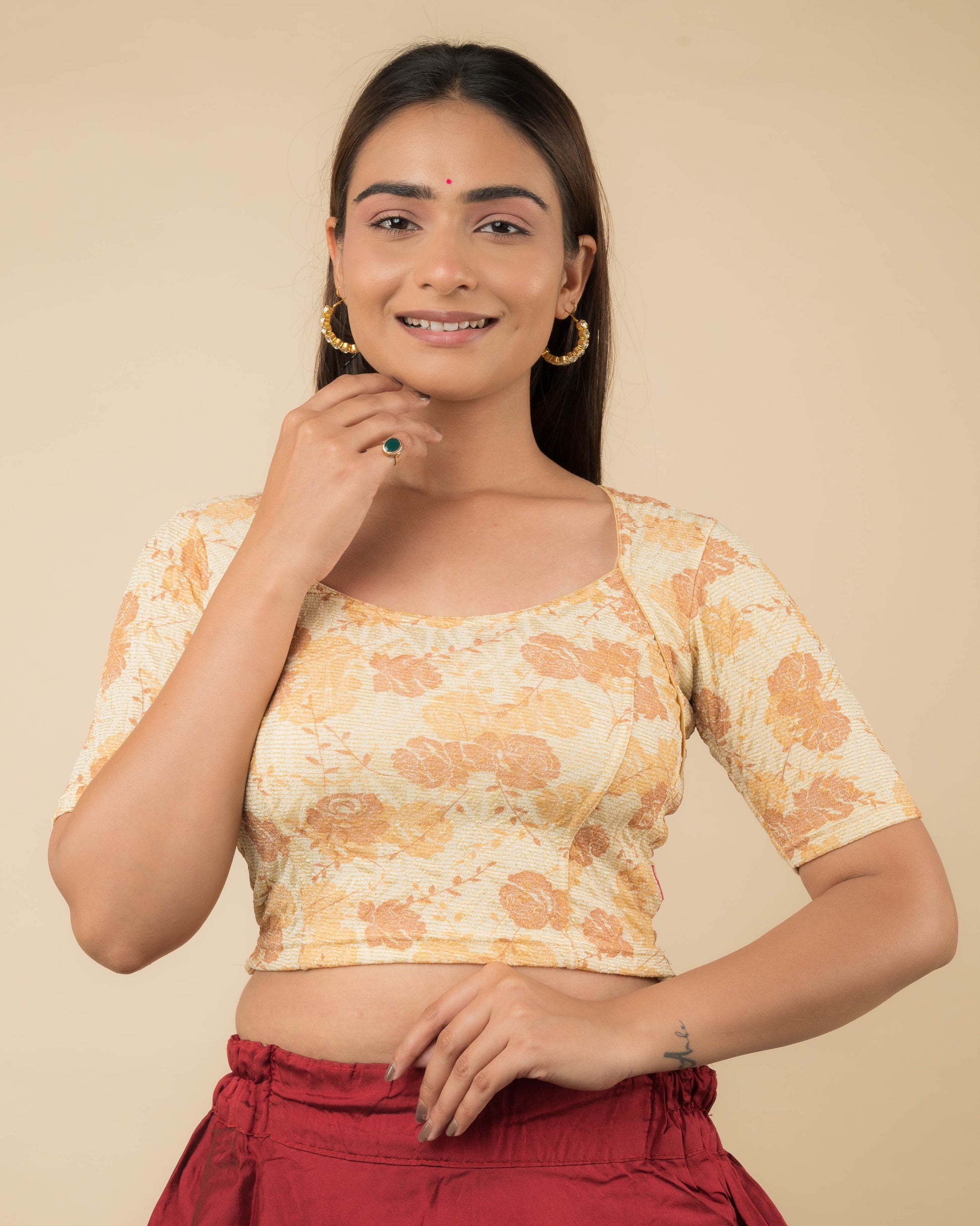  Model wearing a metallic floral stretchable readymade blouse with elbow sleeves and sweetheart neckline.
