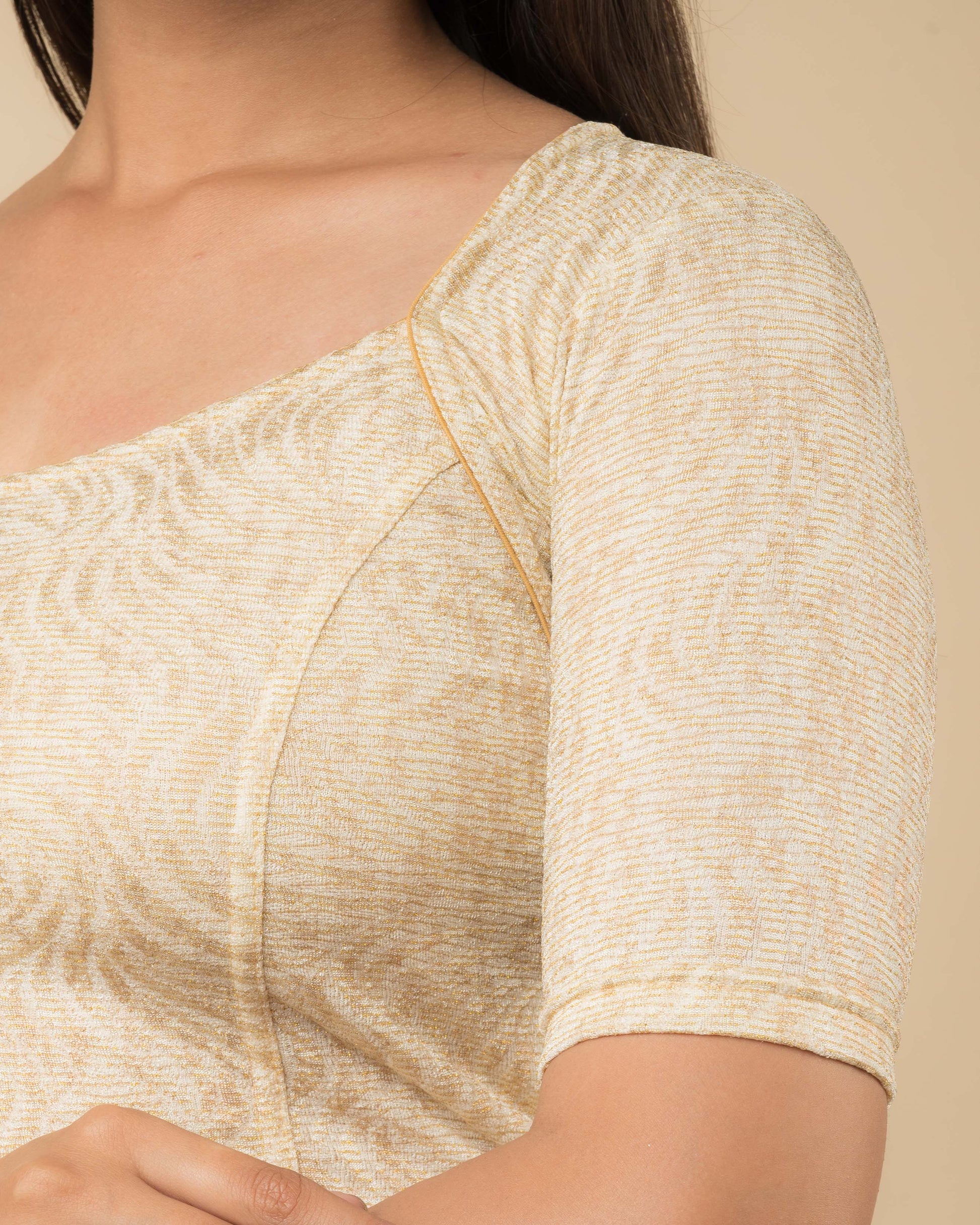  Close-up of the jacquard fabric detailing the metallic floral pattern and stretchability of the readymade blouse.