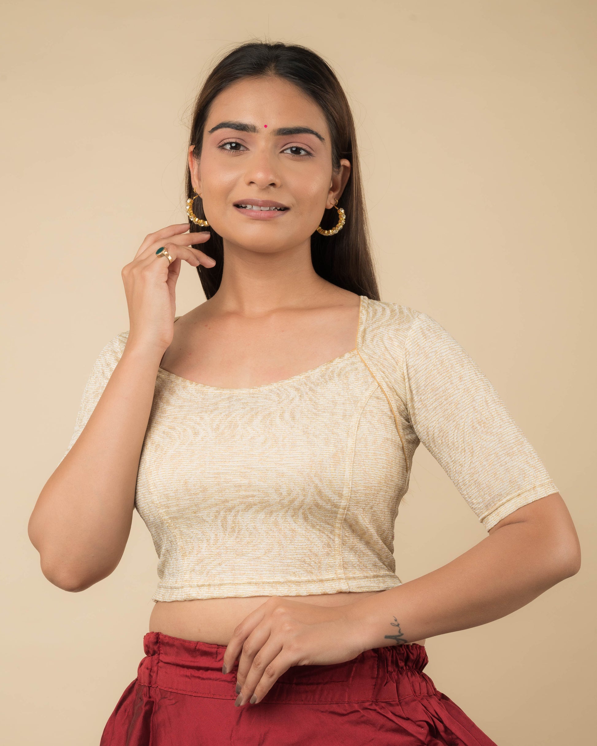 Model wearing a metallic floral stretchable readymade blouse with elbow sleeves and sweetheart neckline.
