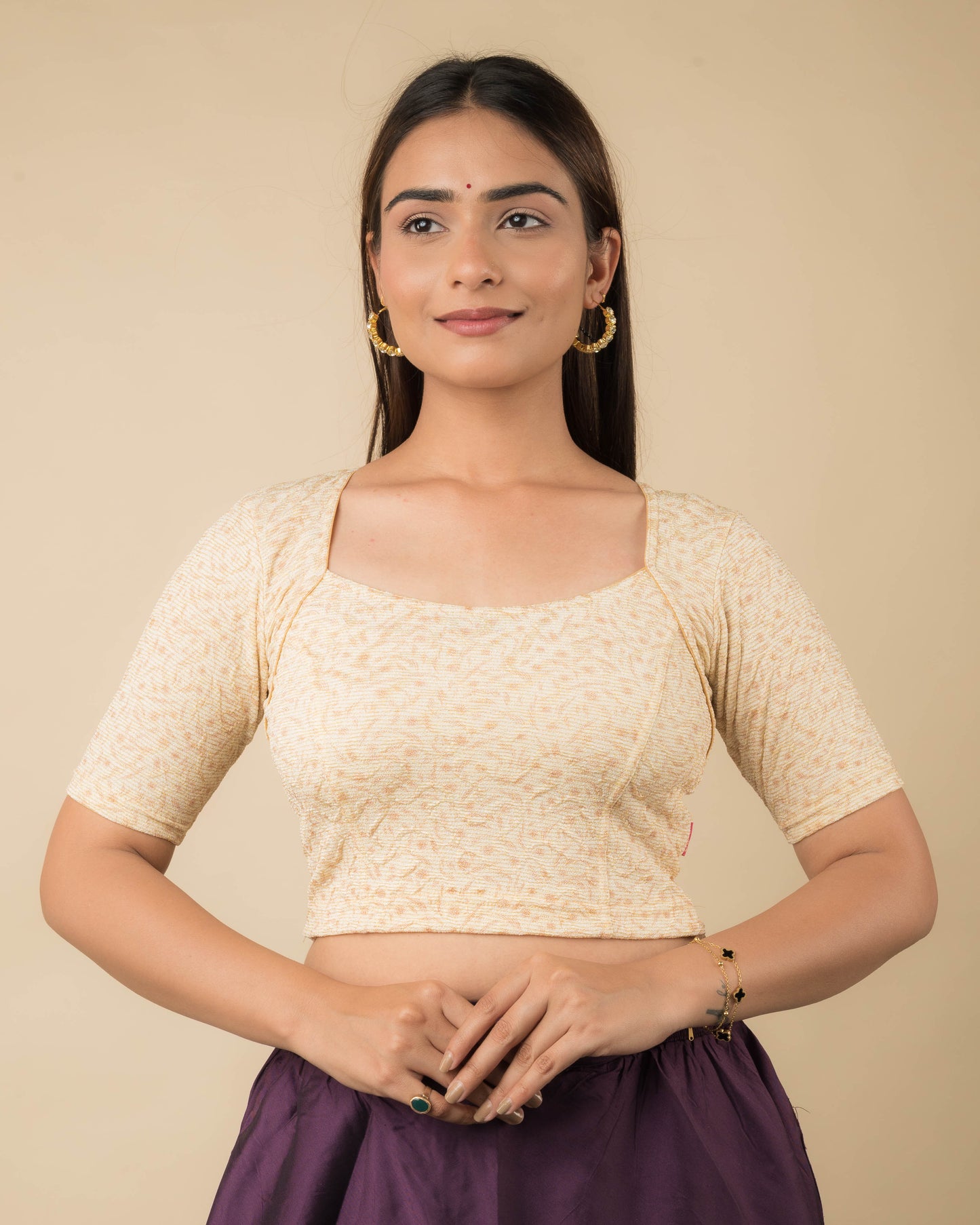 Model wearing a metallic floral stretchable readymade blouse with elbow sleeves and sweetheart neckline.