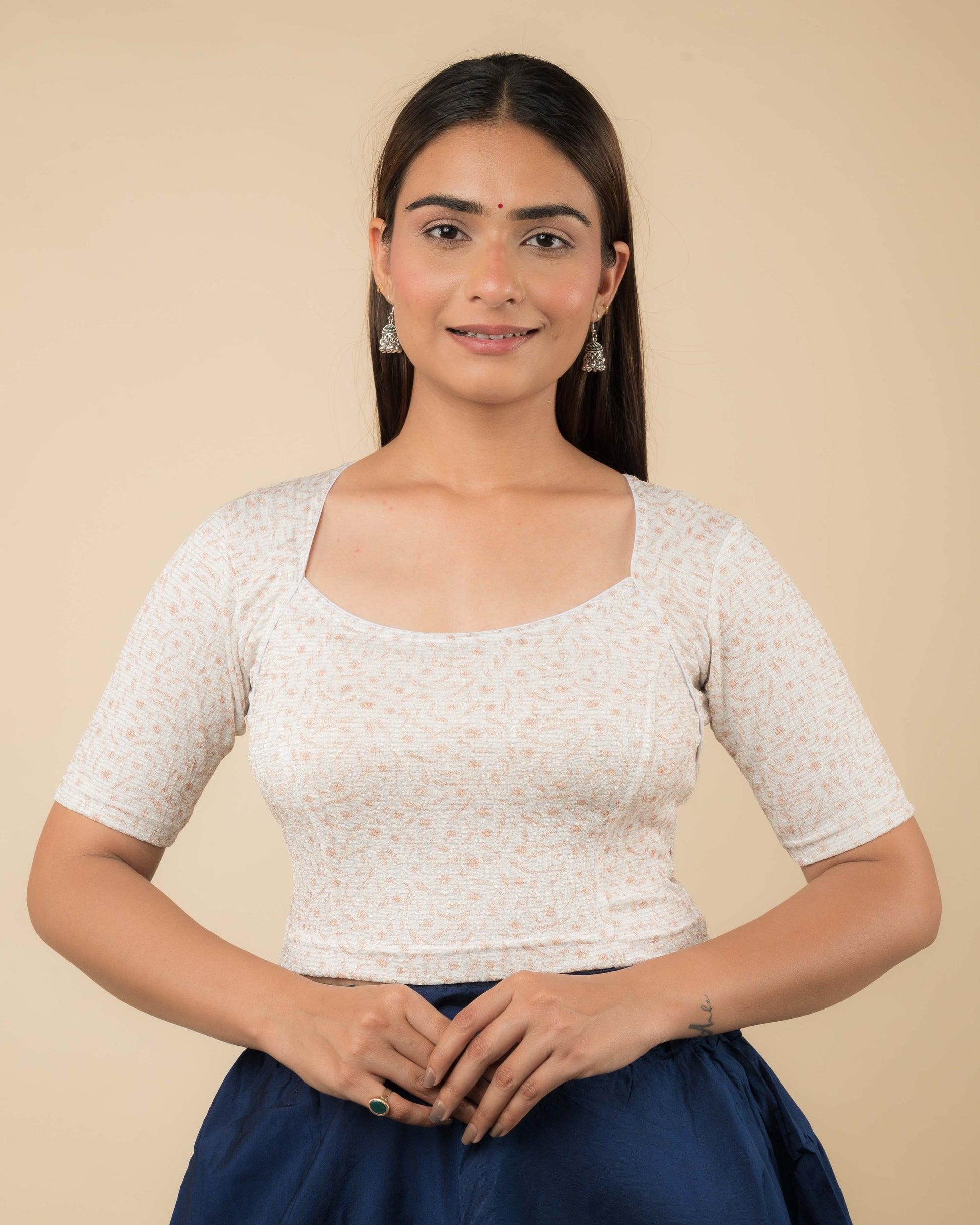 Model wearing a metallic floral stretchable readymade blouse with elbow sleeves and sweetheart neckline.