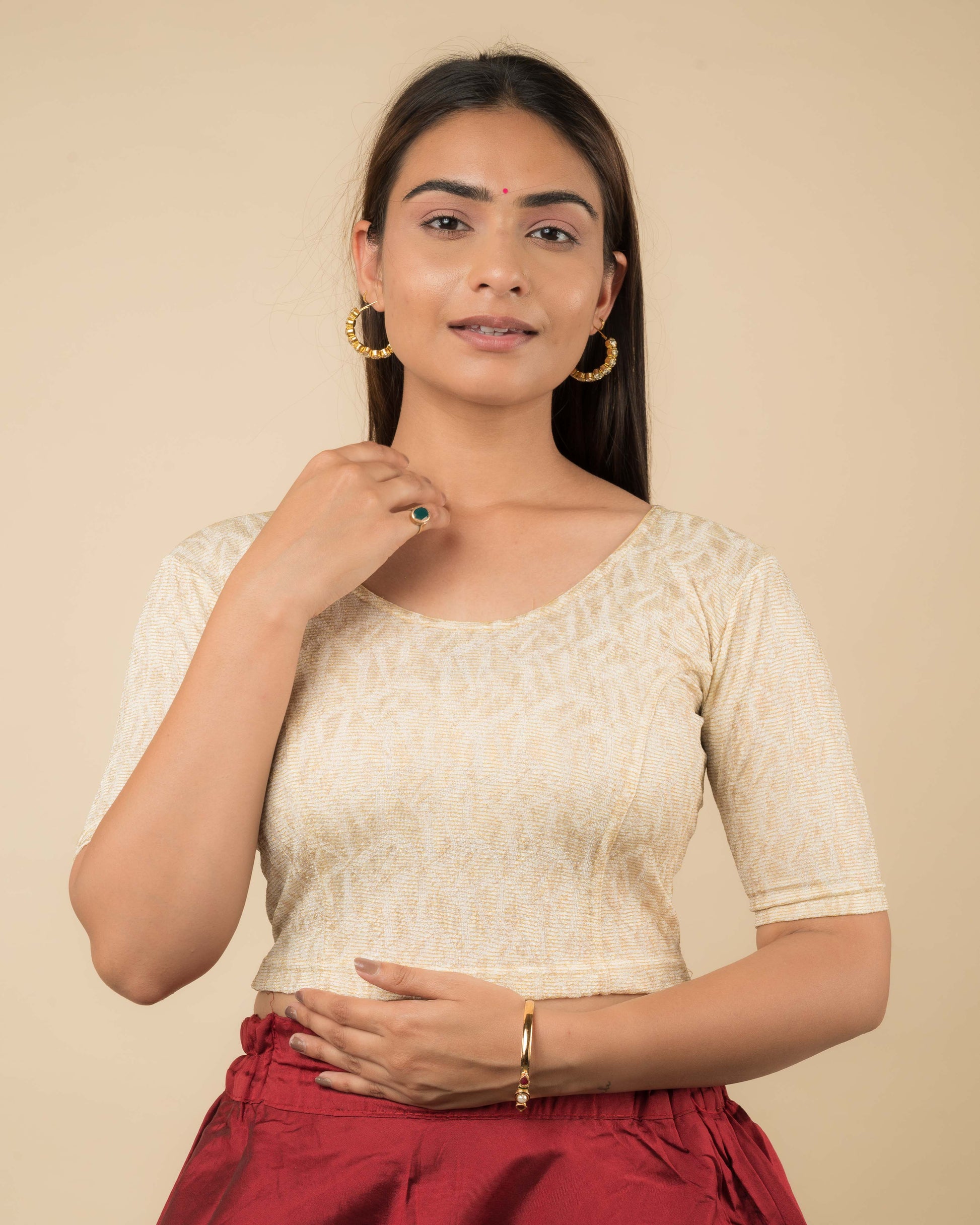 Model wearing a jacquard stretchable readymade blouse with elbow sleeves and round neckline.