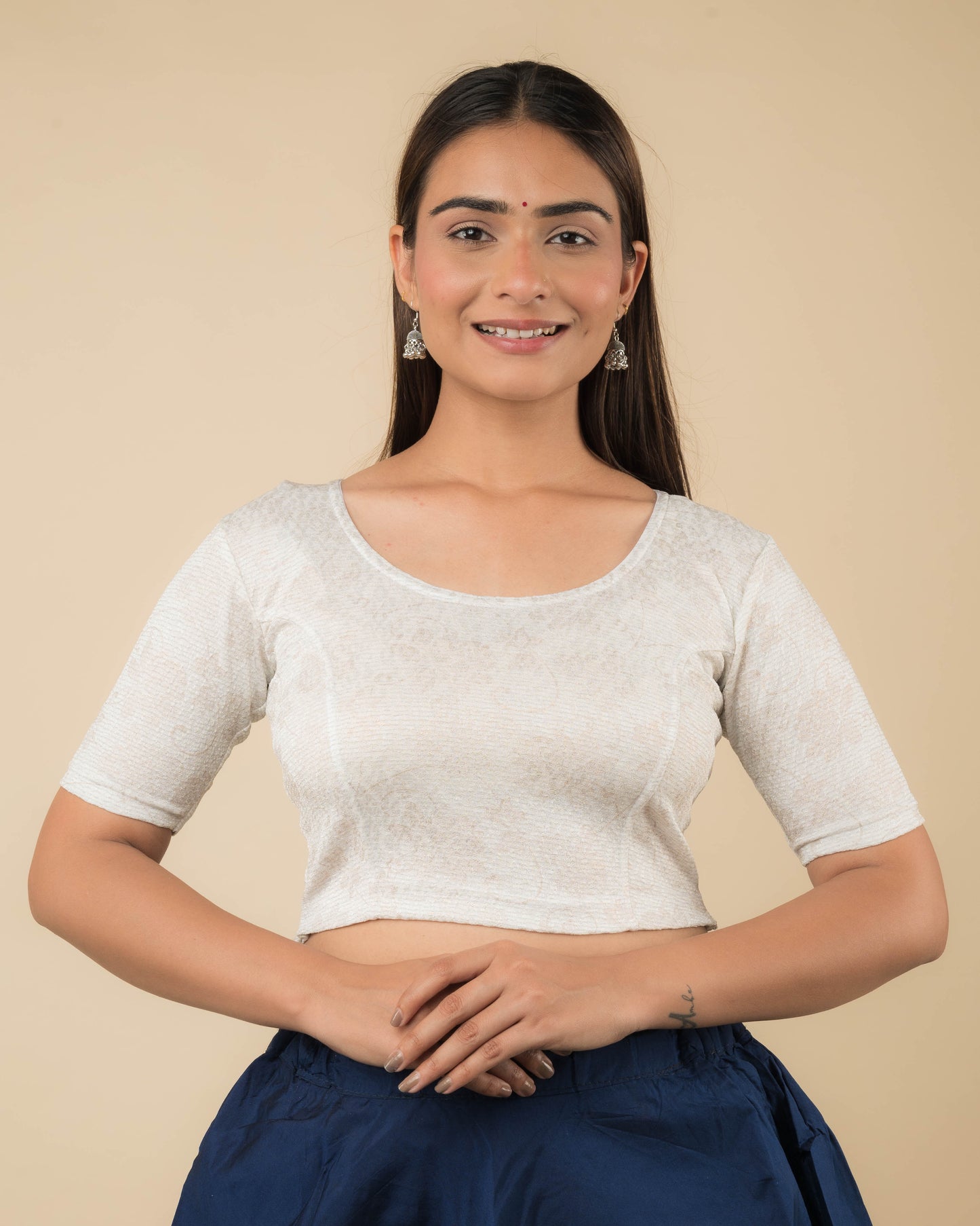 Model wearing a jacquard stretchable readymade blouse with elbow sleeves and round neckline.