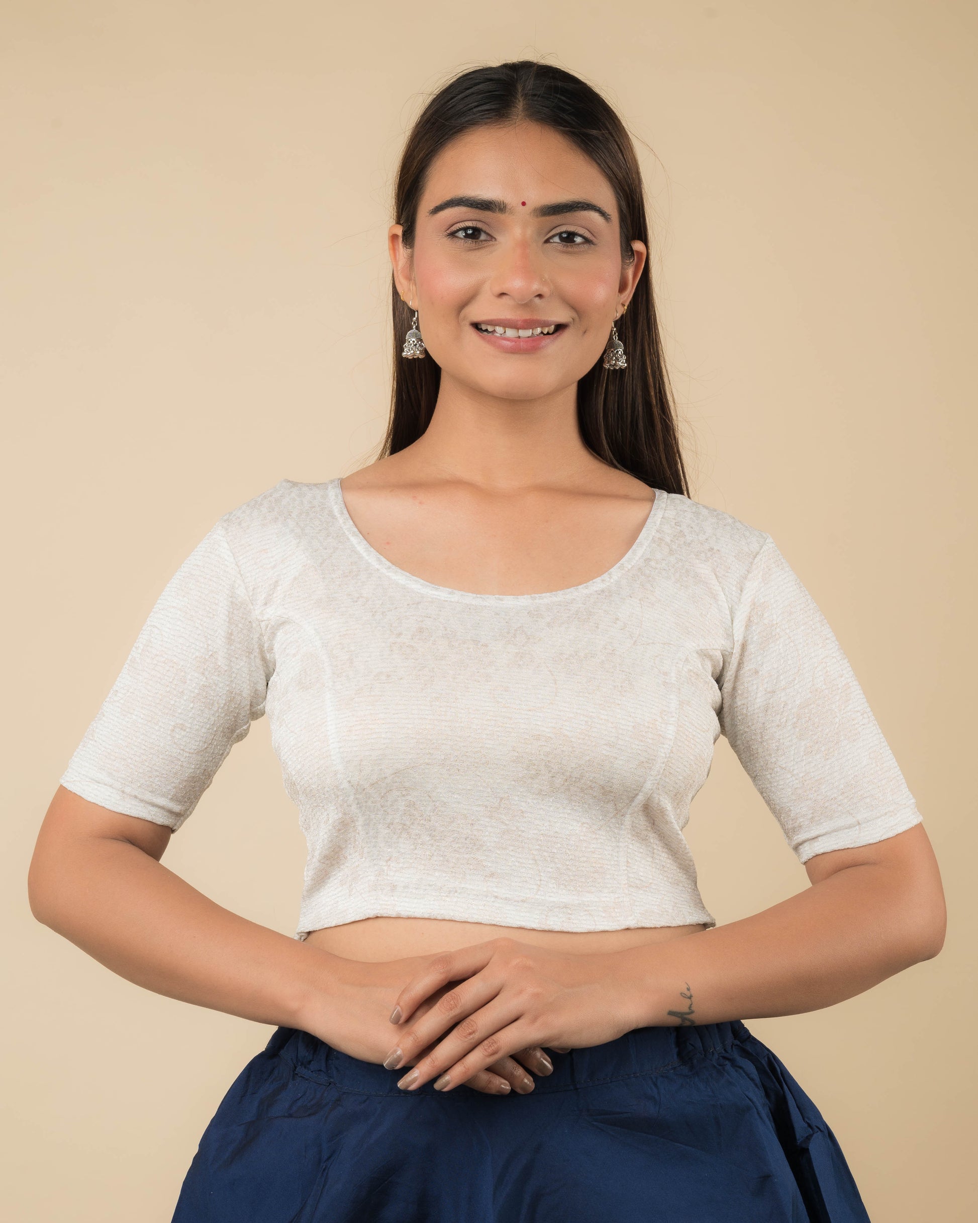 Model wearing a jacquard stretchable readymade blouse with elbow sleeves and round neckline.