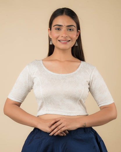 Model wearing a jacquard stretchable readymade blouse with elbow sleeves and round neckline.