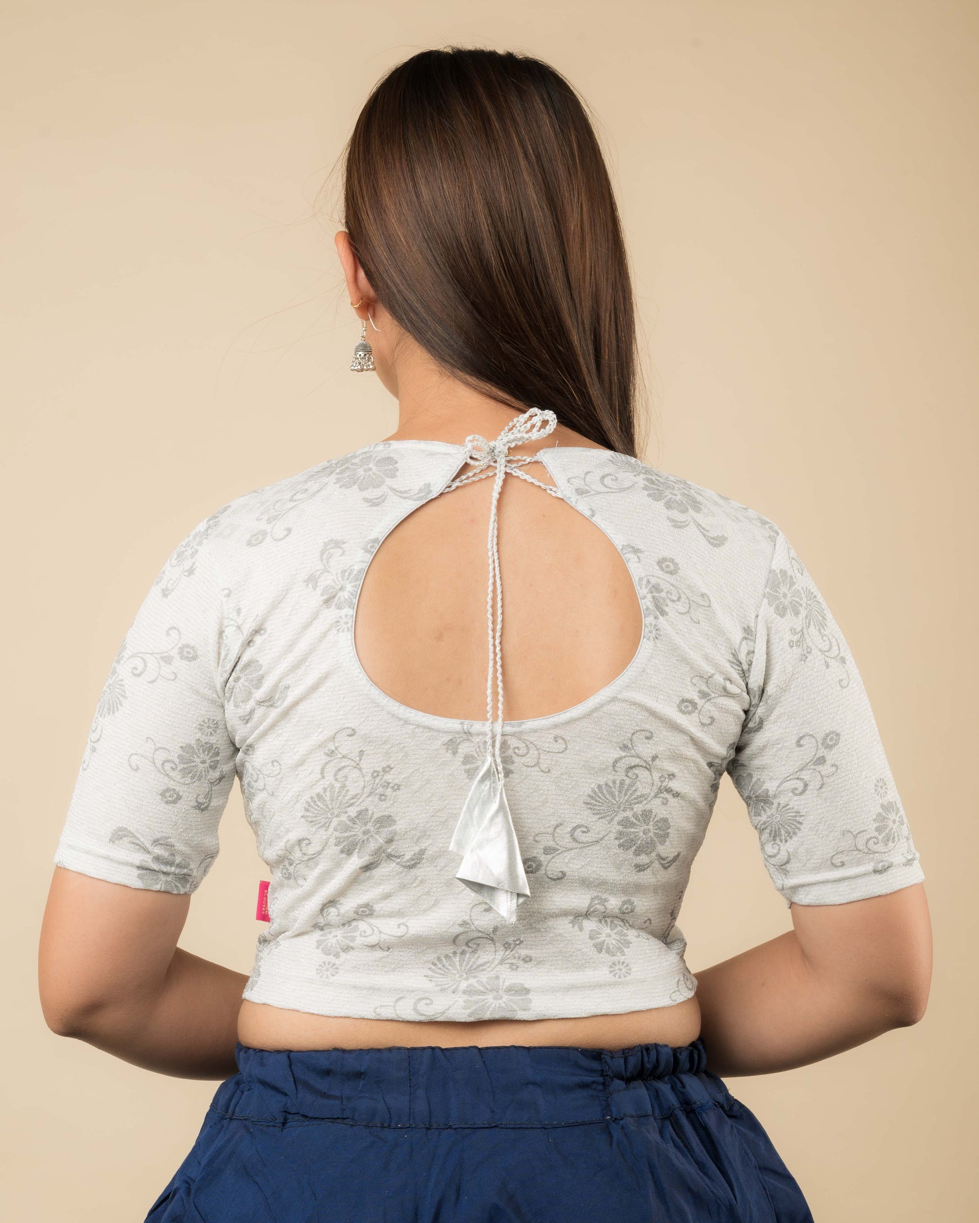 Rear view of the champagne gold jacquard stretchable blouse showcasing the dori tie-up with tassels.
