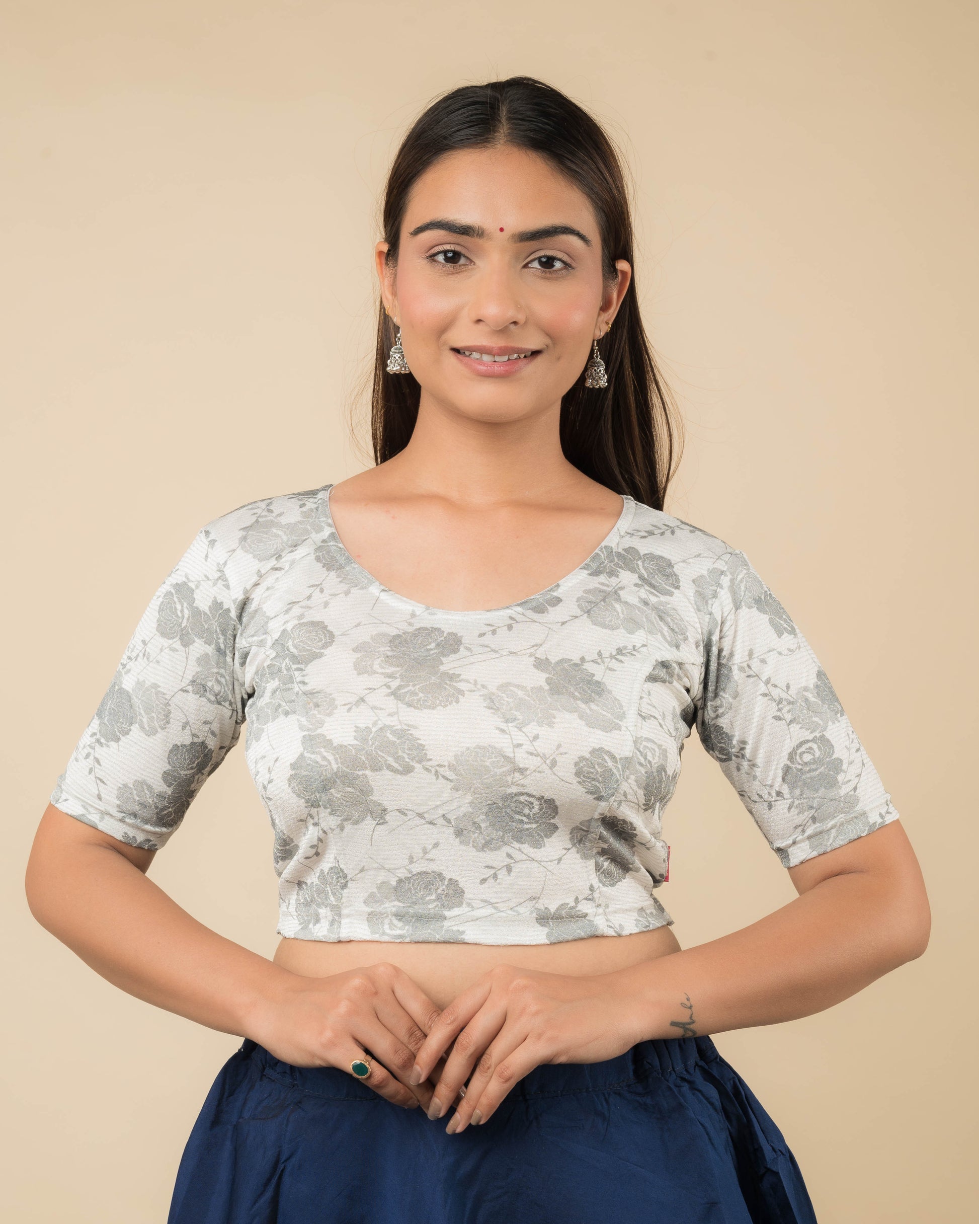 Model wearing a jacquard stretchable readymade blouse with elbow sleeves and round neckline.