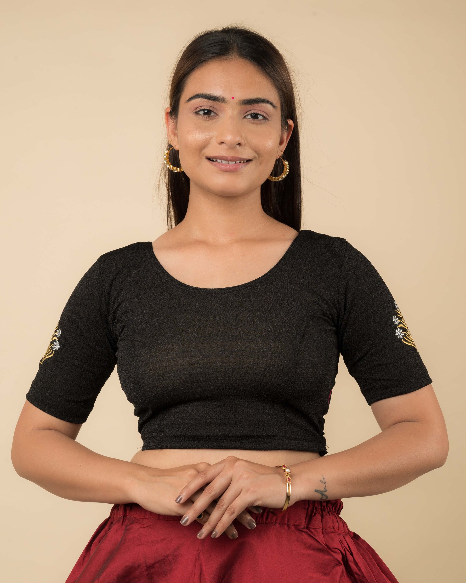 Model wearing a buti embroidered stretchable readymade blouse with elbow sleeves and round neckline.
