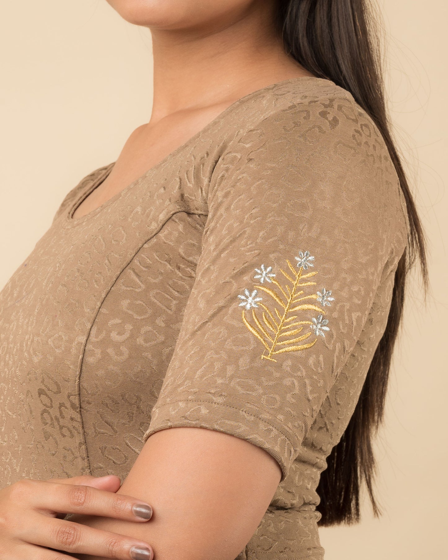 Close-up of the stretchable knit fabric detailing the buti embroidery of the readymade blouse.
