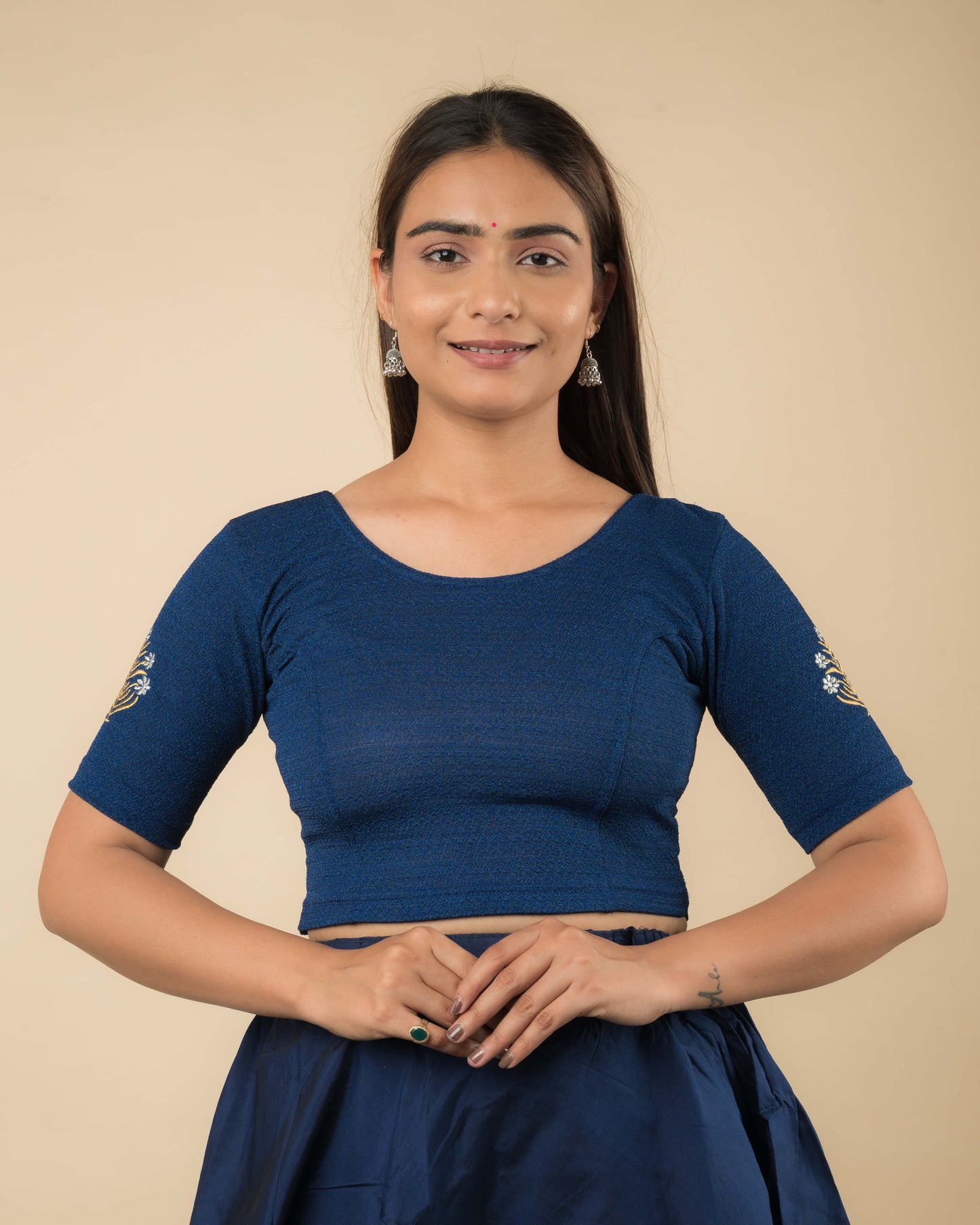 Model wearing a buti embroidered stretchable readymade blouse with elbow sleeves and round neckline.