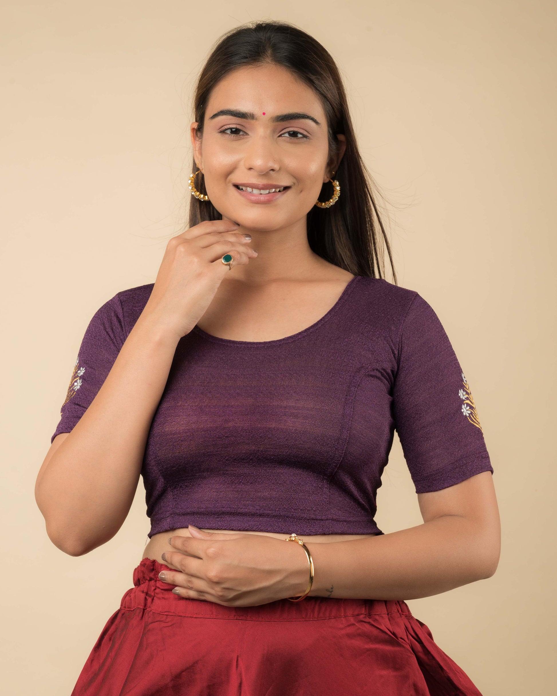 Model wearing a buti embroidered stretchable readymade blouse with elbow sleeves and round neckline.
