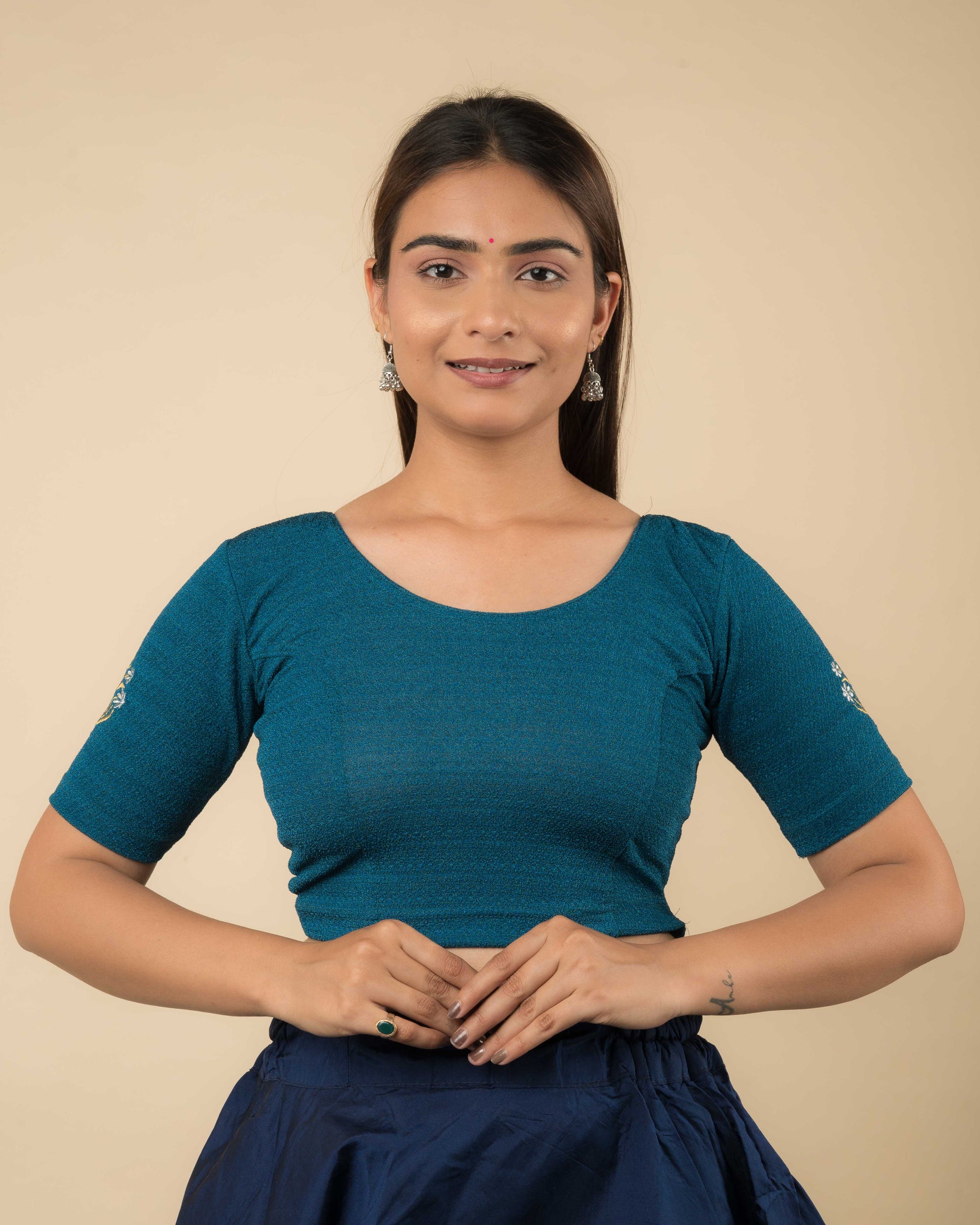 Model wearing a buti embroidered stretchable readymade blouse with elbow sleeves and round neckline.