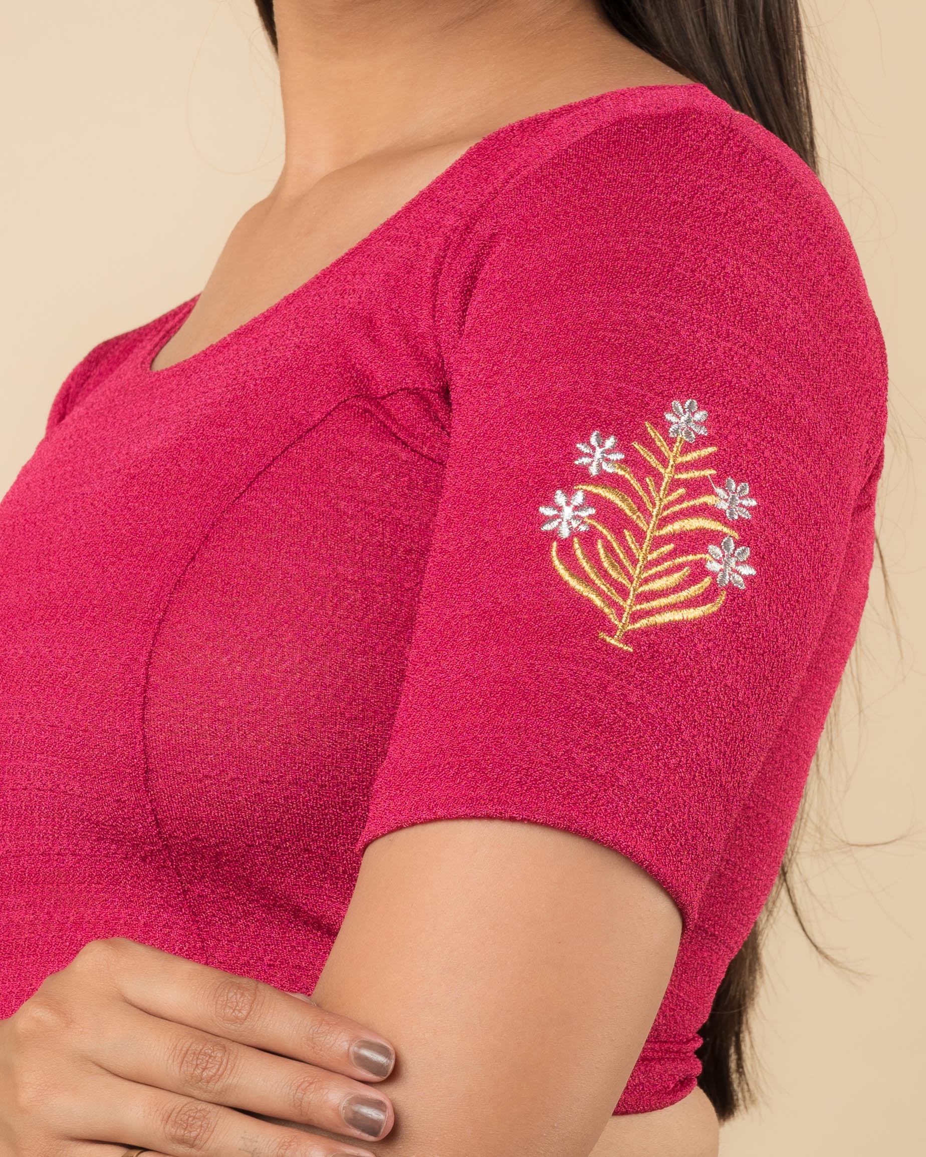 Close-up of the stretchable knit fabric detailing the buti embroidery of the readymade blouse.