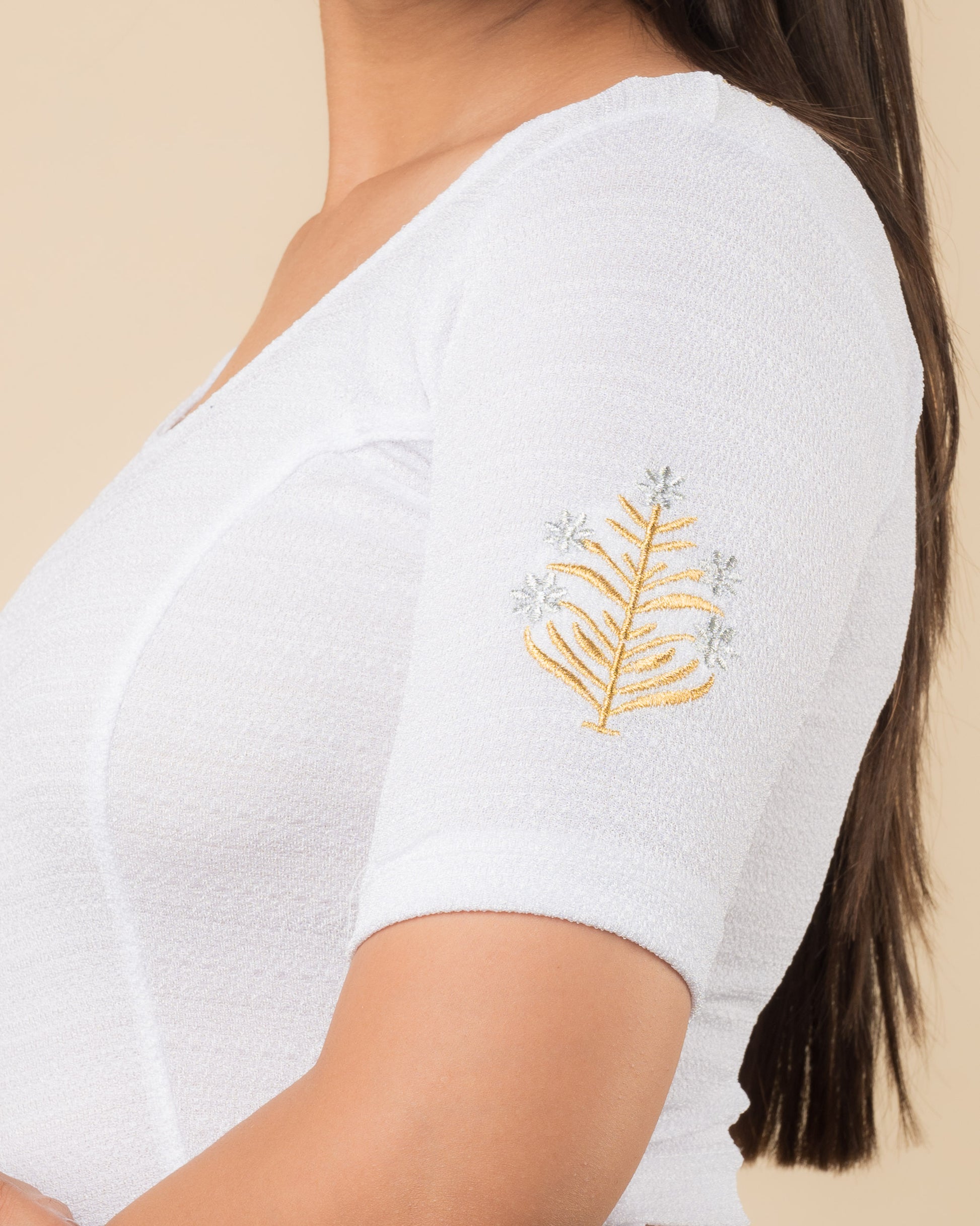 Close-up of the stretchable knit fabric detailing the buti embroidery of the readymade blouse.