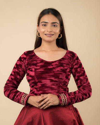 Model wearing a velvet stretchable readymade blouse with full sleeves and round neckline.