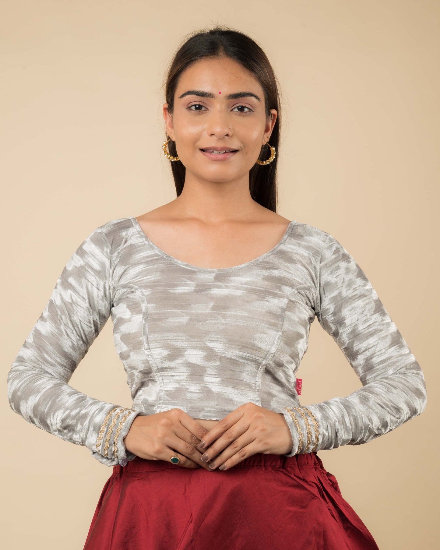 Model wearing a velvet stretchable readymade blouse with full sleeves and round neckline.