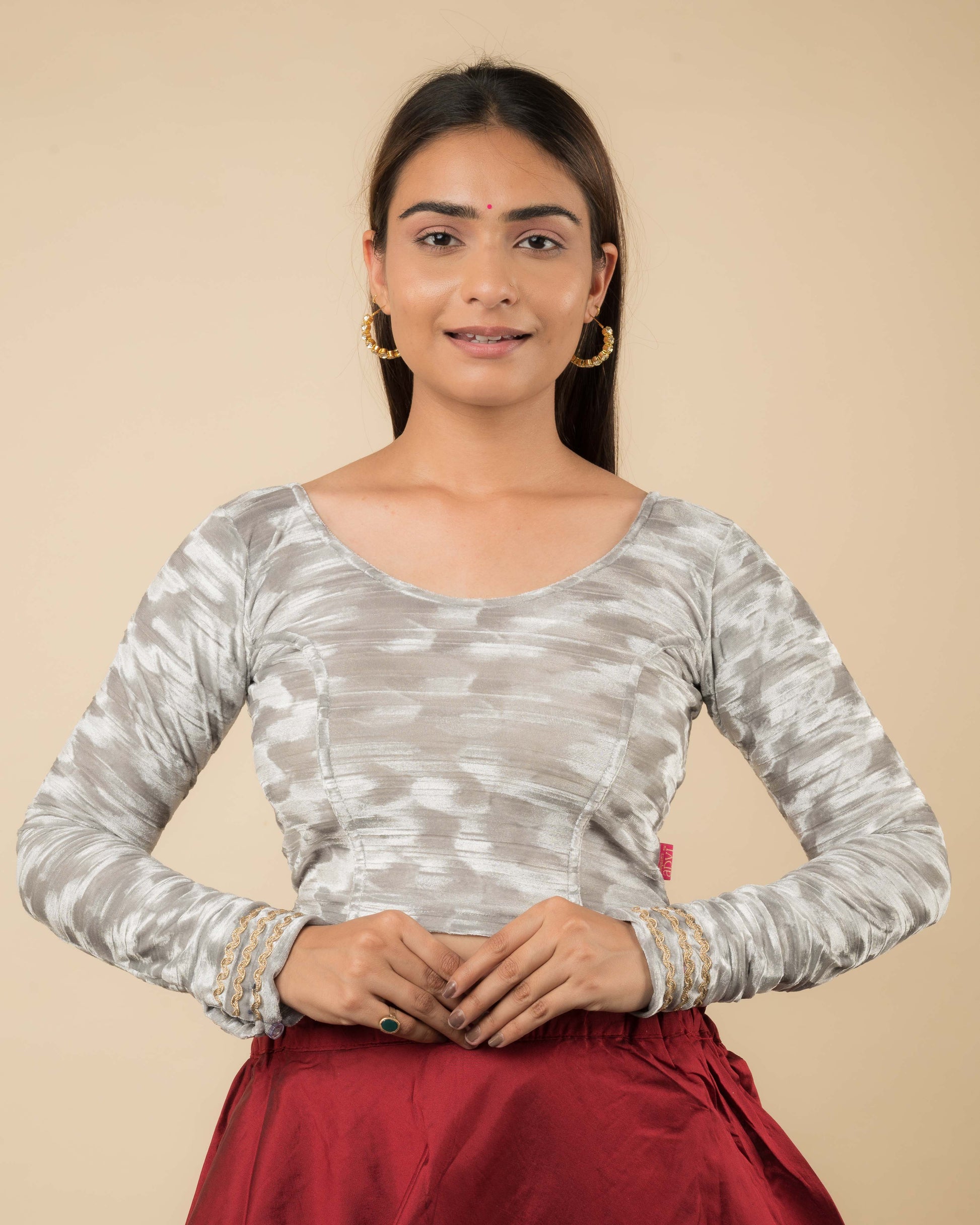 Model wearing a velvet stretchable readymade blouse with full sleeves and round neckline.
